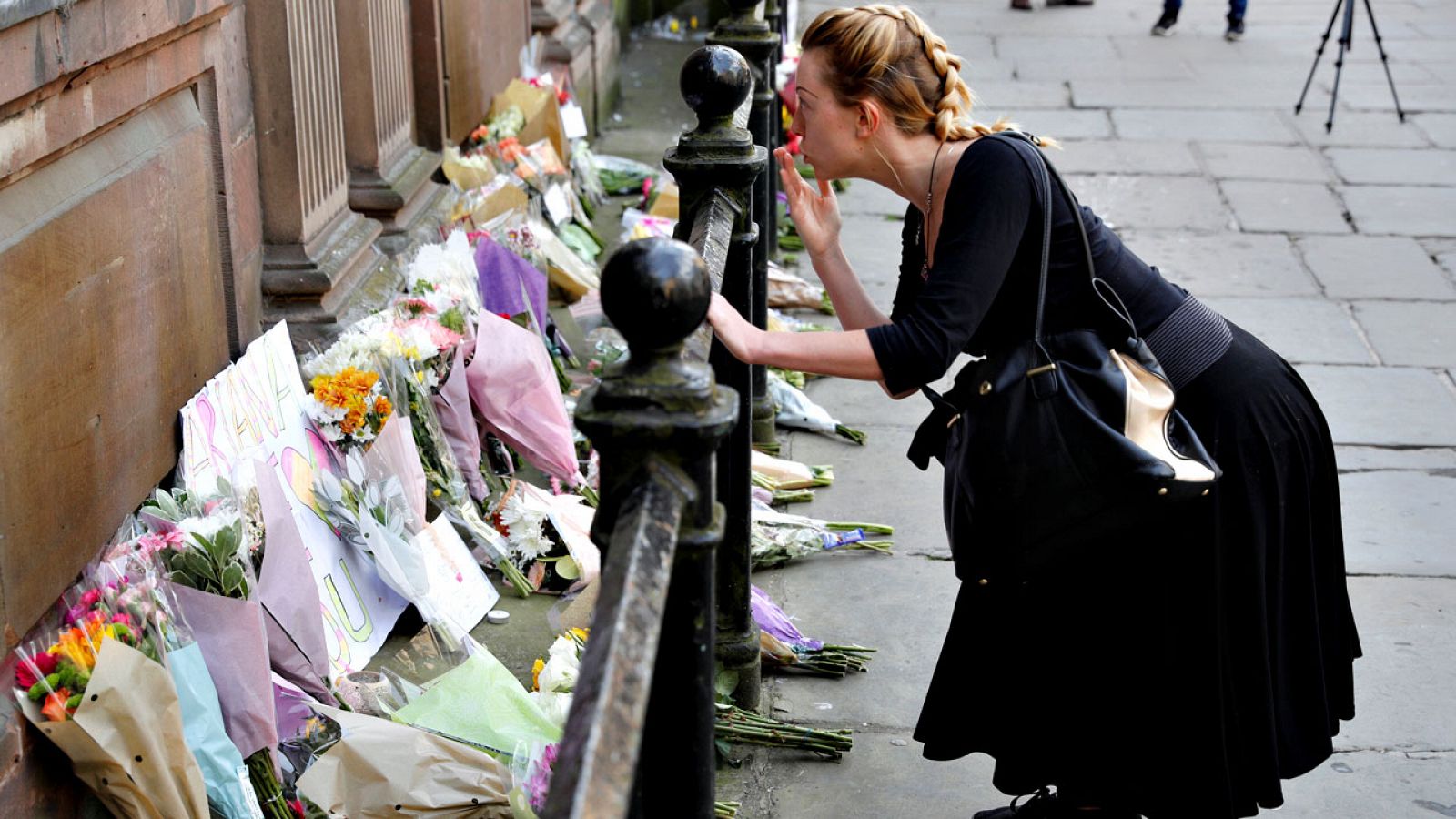 Una mujer lanza un beso tras depositar flores en recuerdo de las víctimas del atentado de Mánchester