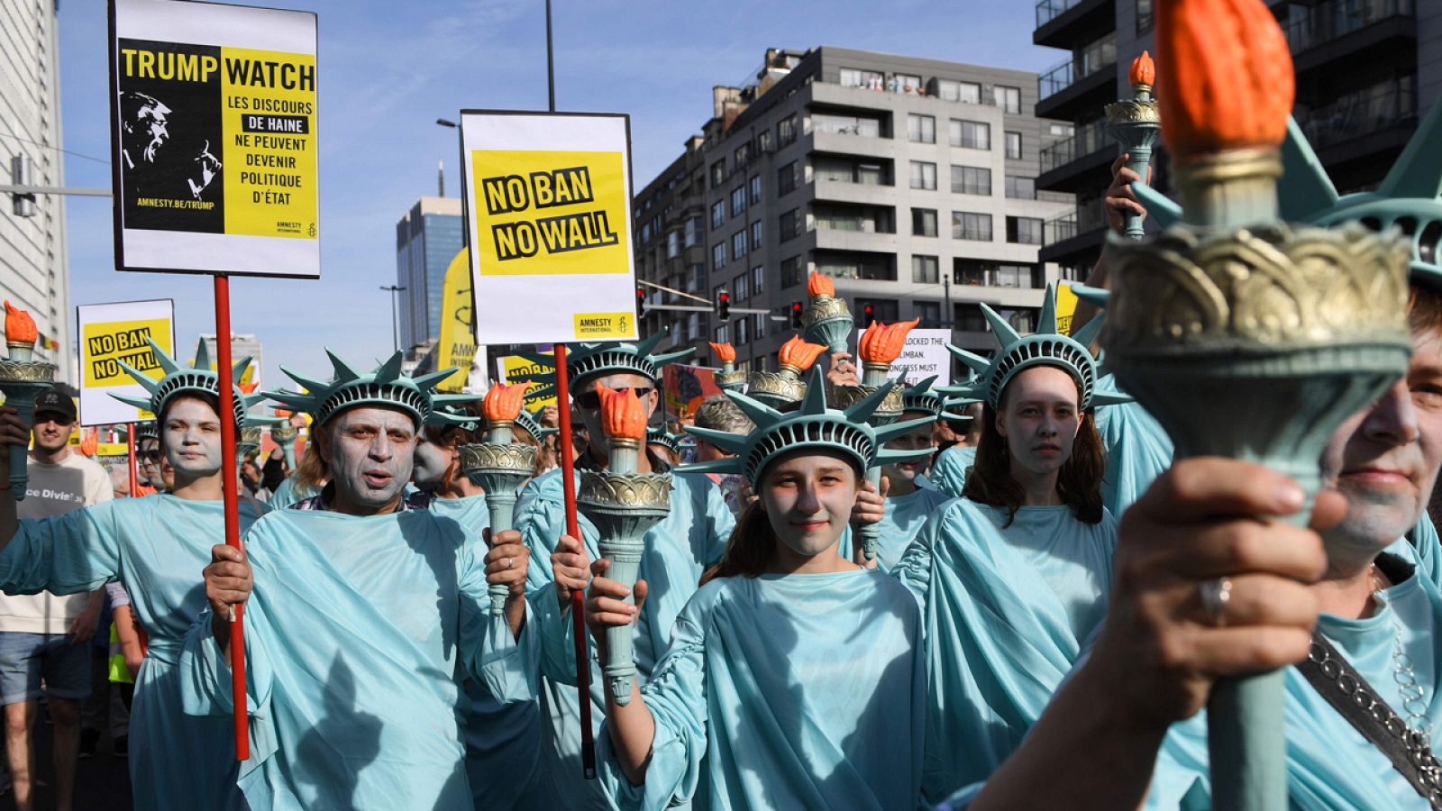 Manifestantes disfrazados de Estatua de la Libertad protestan contra el veto migratorio de Trump en Bruselas