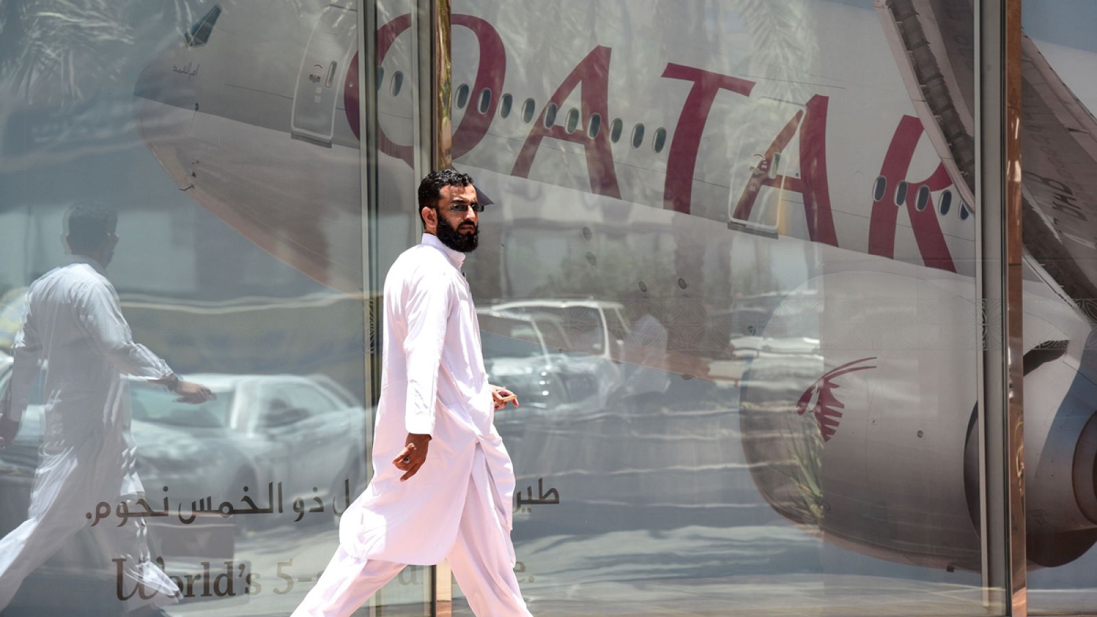 Un hombre camina delante de un avión de Qatar Airways en la capital saudí, Rihad.