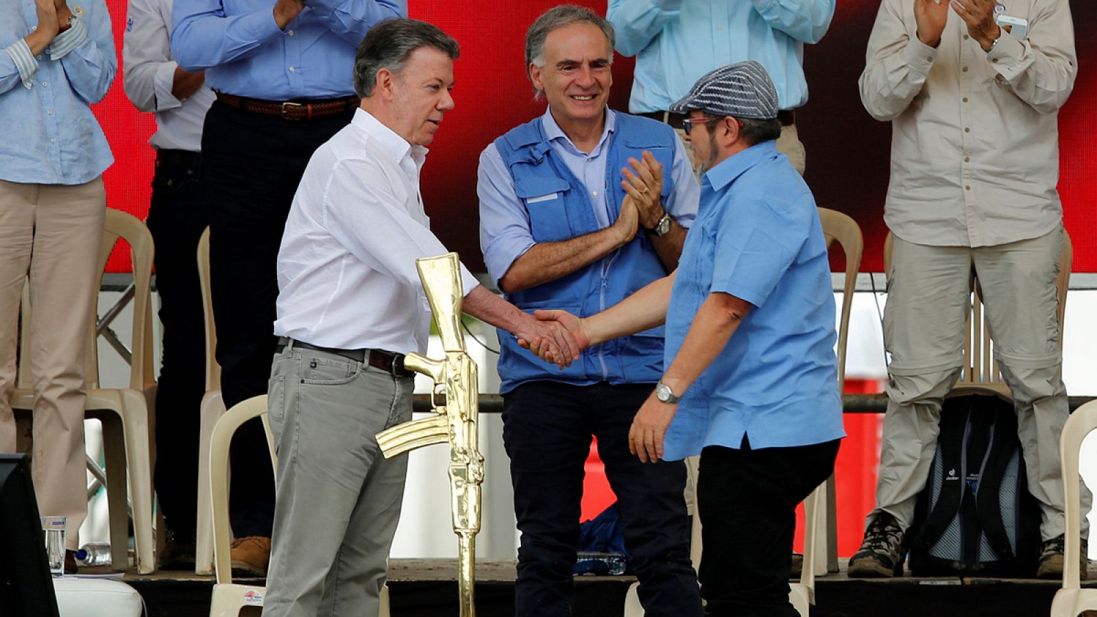 El líder de las FARC conocido como 'Timochenko' estrecha la mano del presidente de Colombia, Juan Manuel Santos, en presencia del representante especial de la ONU.