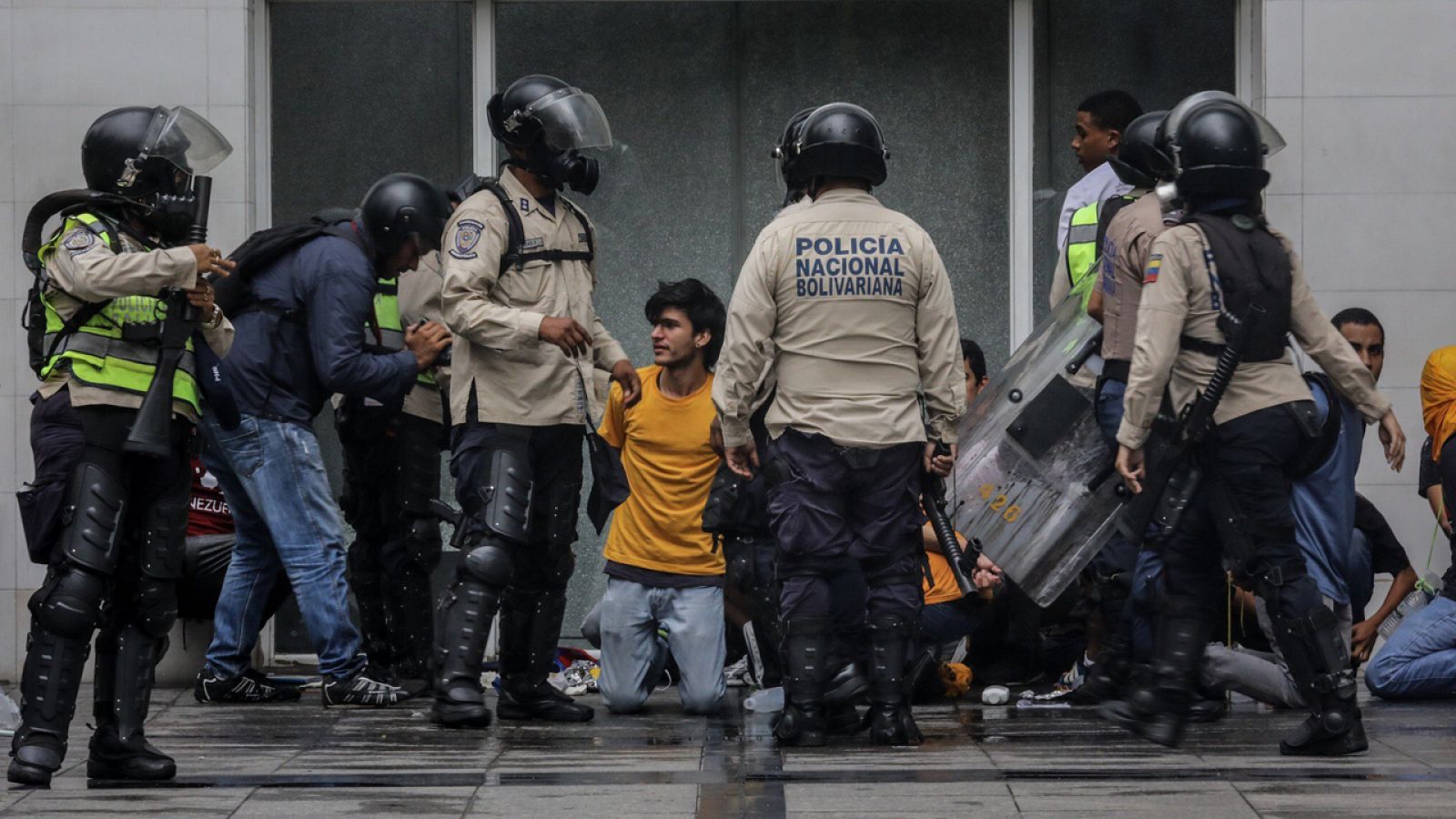 Agentes de la Policía Nacional Bolivariana detienen a manifestantes durante una marcha en Caracas