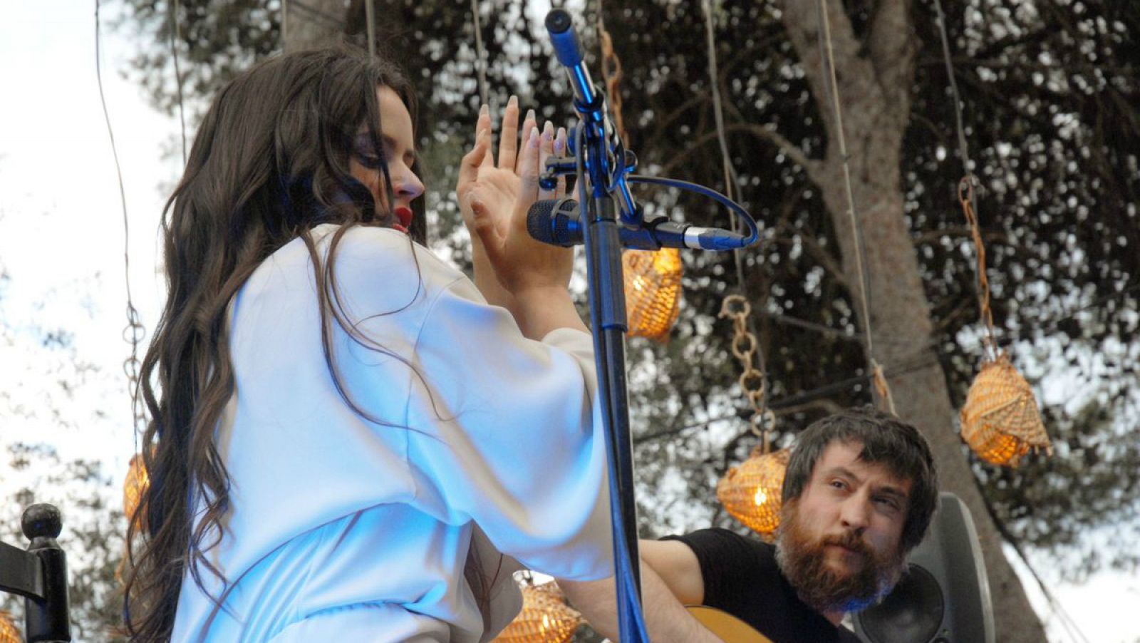 Rosalía y Raúl Fernández 'Refree' en el escenario del barco, entre áboles y con peces flotando sobre ellos.