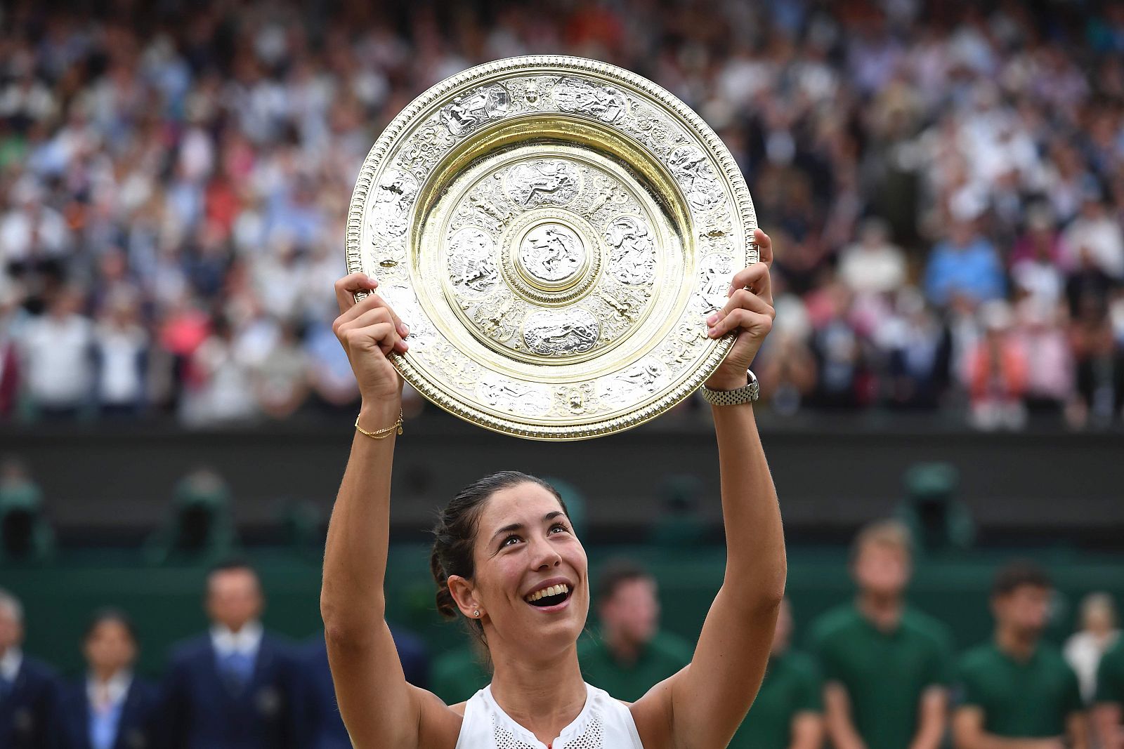 Garbiñe muestra el plato que la acredita como campeona de Wimbledon.
