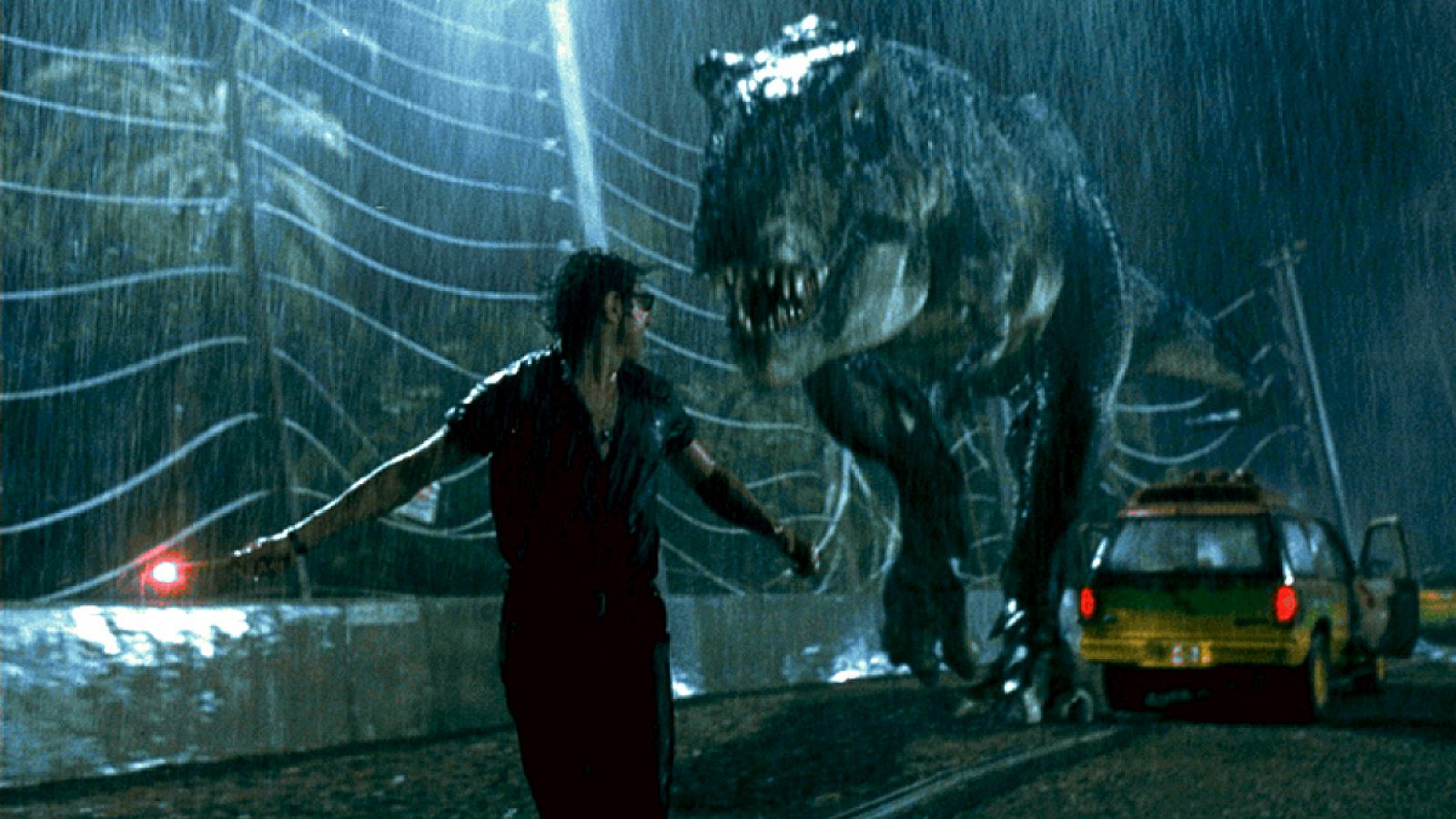 Escena de Jurassic Park con el tiranosaurio persiguiendo al personaje interpretado por Jeff Goldblum
