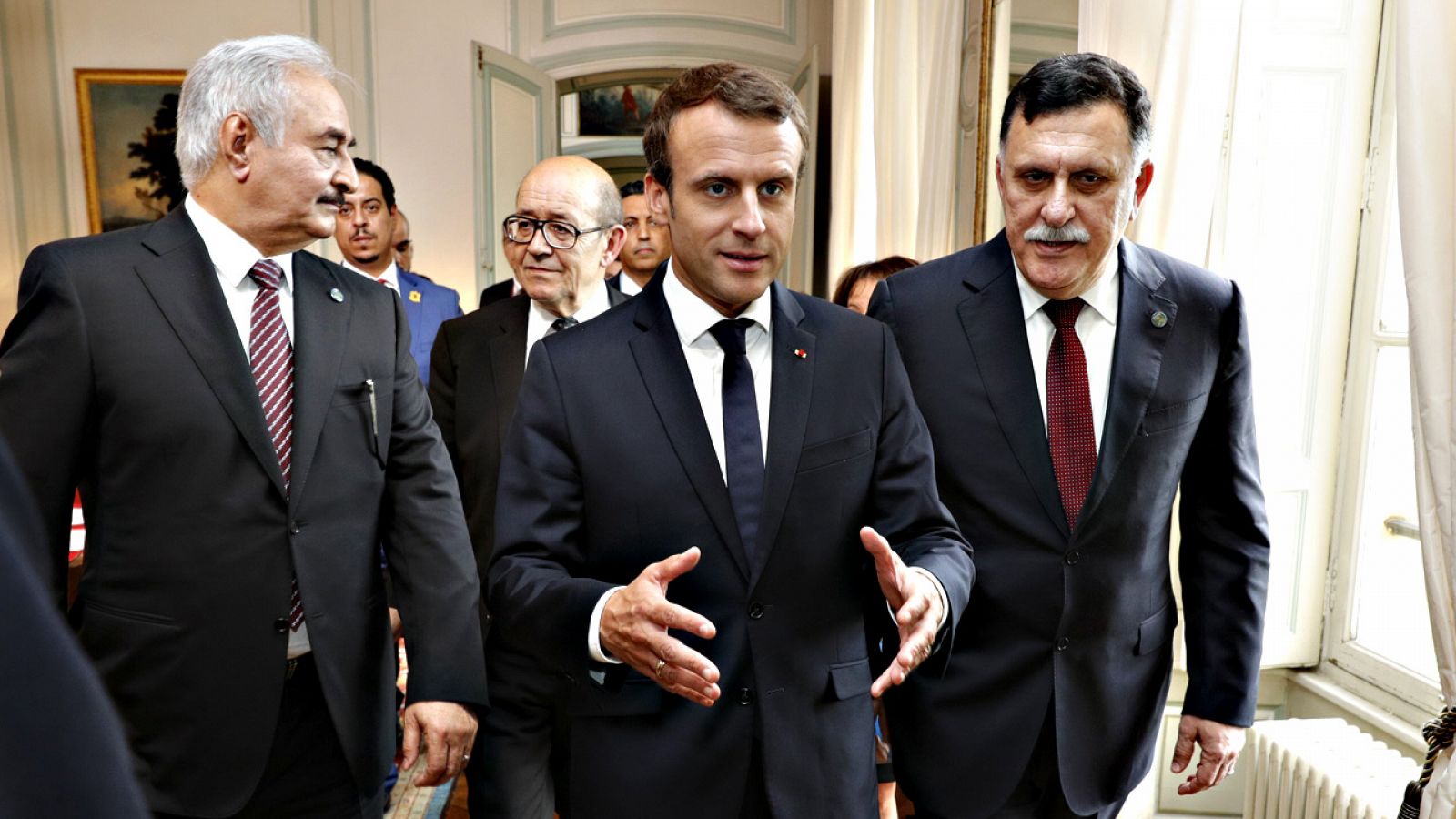 El mariscal Jalifa Hafter, a la izquierda, y el líder del Gobierno de unidad nacional libio, Fayez al Serraj, caminan junto al presidente francés, Emmanuel Macron