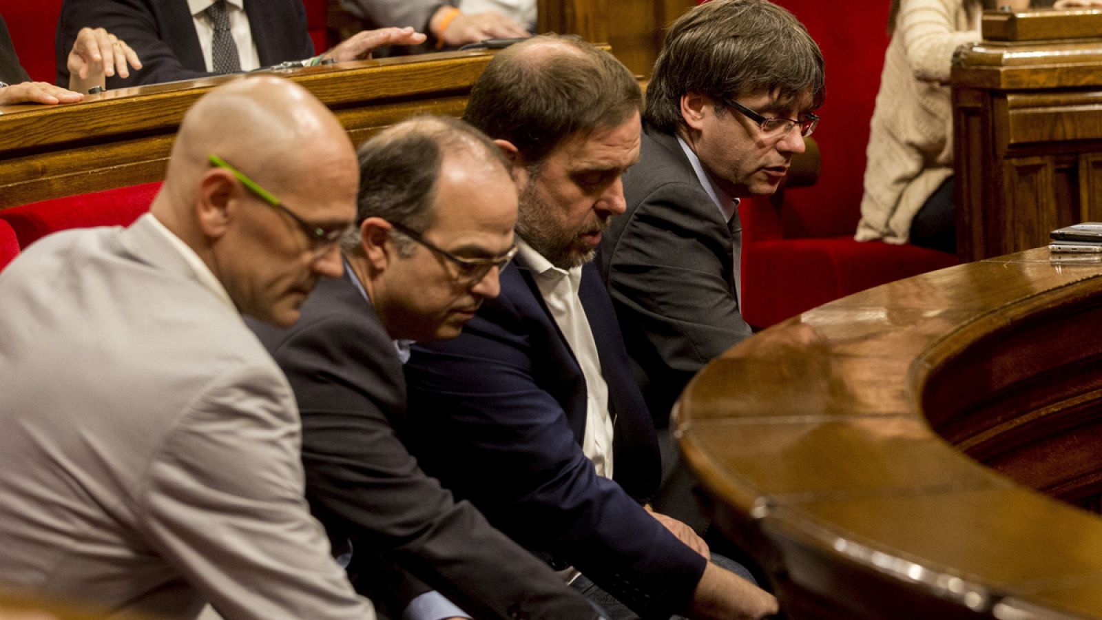 El presidente de la Generalitat, Carles Puigdemont, junto al vicepresidente Oriol Junqueras (3i), el conseller de la Presidencia Jordi Turull (2i) y el conseller de Exteriores, Raül Romeva (d), emiten su voto, durante el pleno del parlamento de Cataluña.