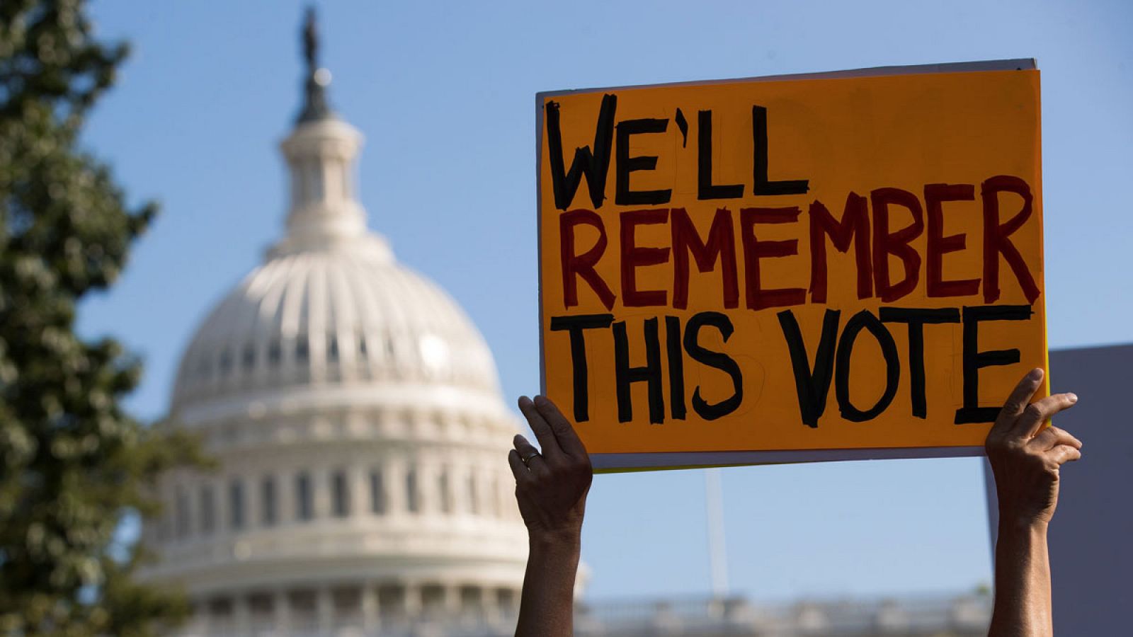Imagen de un manifestante con una pancarta en contra de la derogación del Obamacare frente al Capitolio de Washington (EE.UU.).