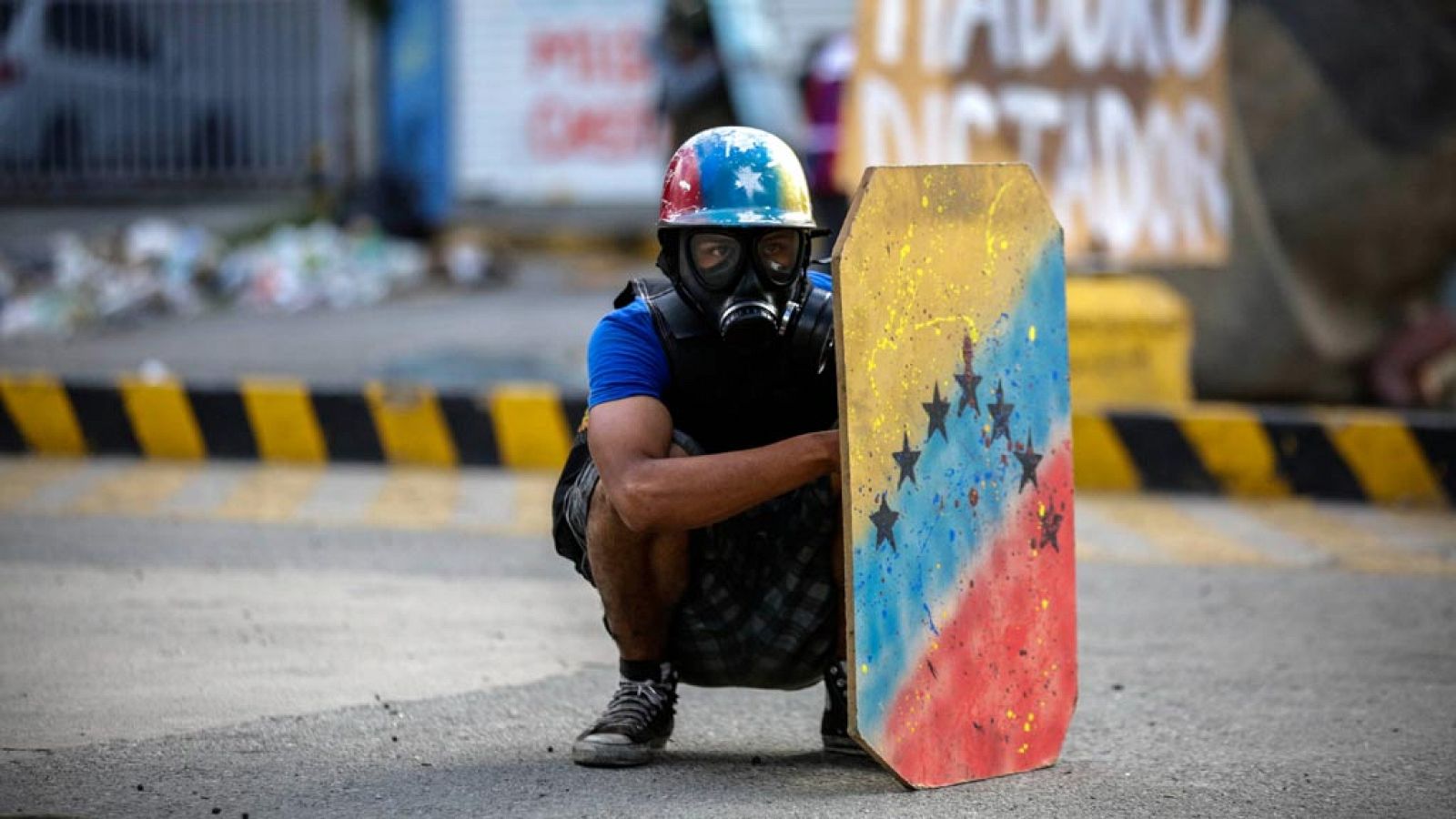 Un manifestante se protege durante uno de los "trancazos" celebrado en Venezuela