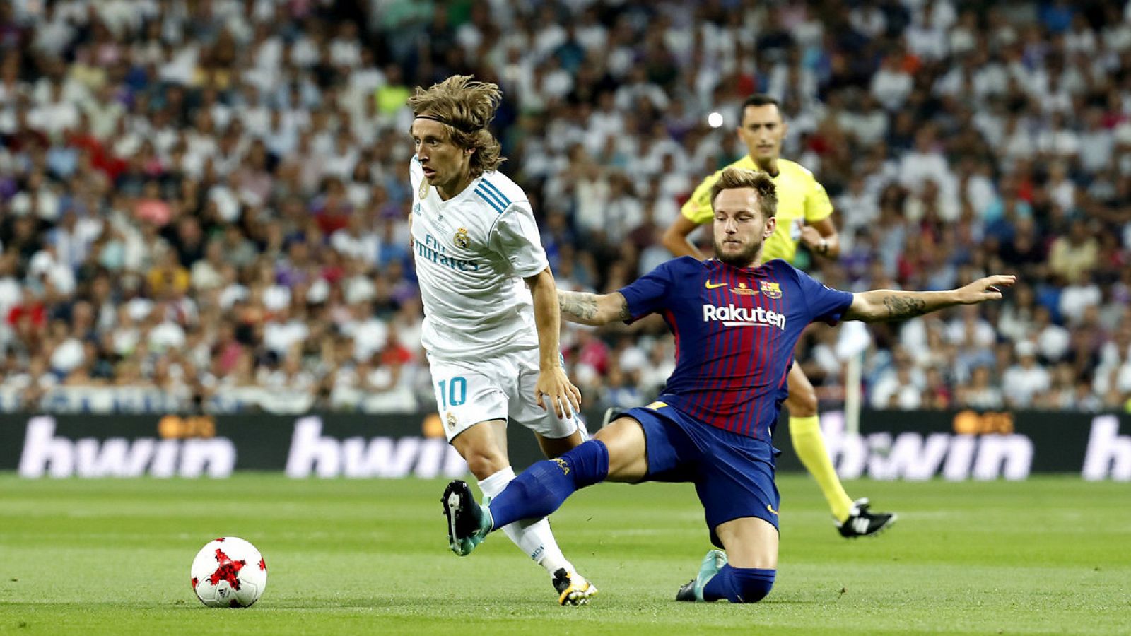 Modric trata de conducir el balón ante Rakitic en un momento del partido