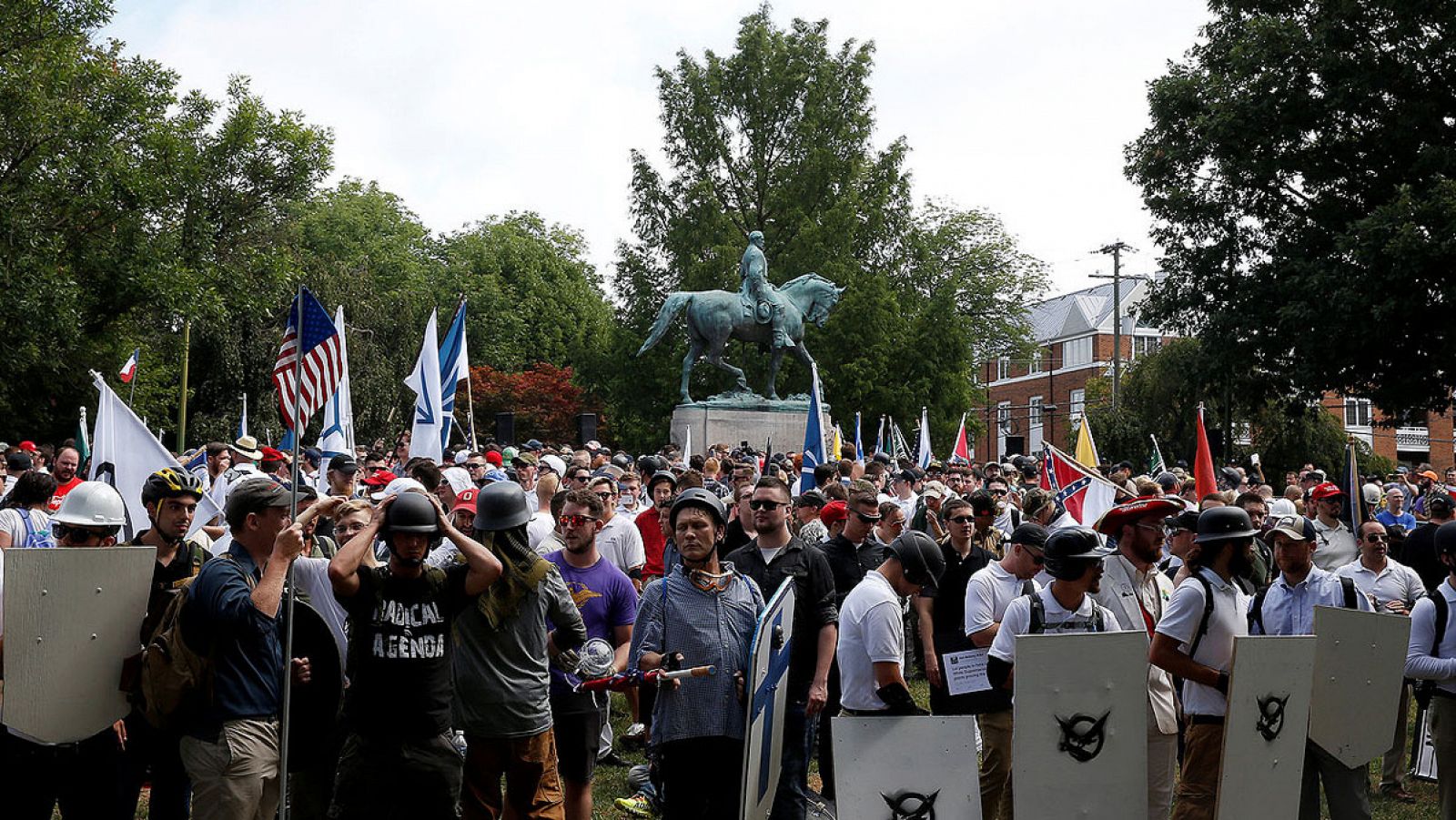 Imagen de la concentración racista frente a la estatua del general confederado Robert E. Lee en Charlottesville, Virginia. Los manifestantes portan banderas, escudos y símbolos de varios grupos de extrema derecha