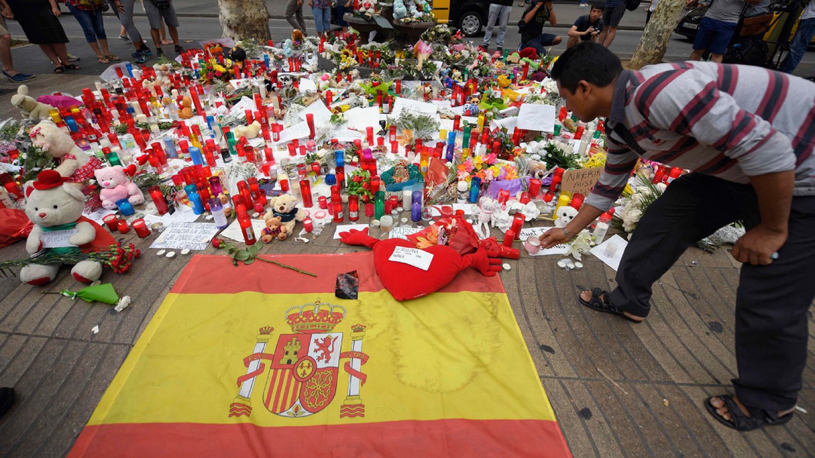 Un hombre rinde tributo a las víctimas del doble atentado en Cataluña dejando una vela en Las Ramblas de Barcelona