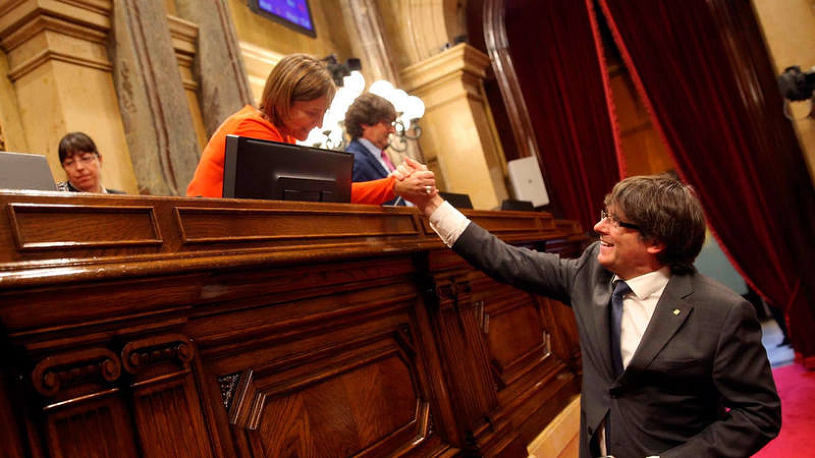 El presidente catalán, Carles Puigdemont, saluda a la presidenta del Parlament, Carme Forcadell