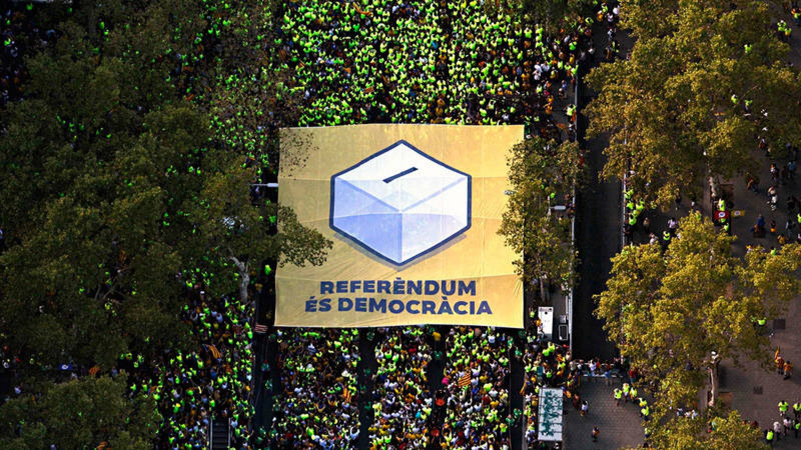 Pancarta desplegada en la manifestación de la Diada en Barcelona con una urna en favor del referendum del 1-O