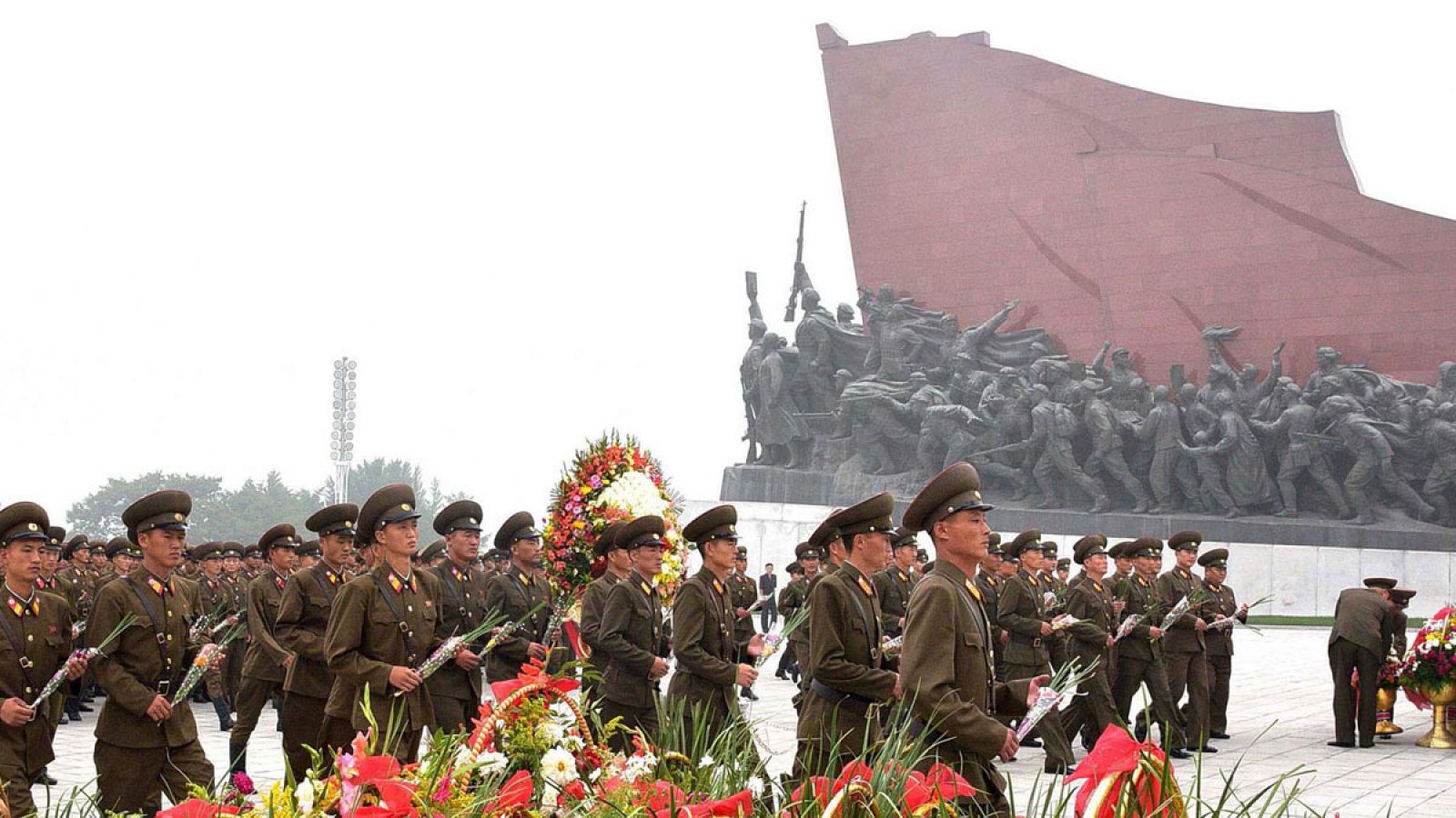 Militares norcoreanos ofrecen flores a las estatuas de sus líderes en el Día Nacional de Corea del Norte