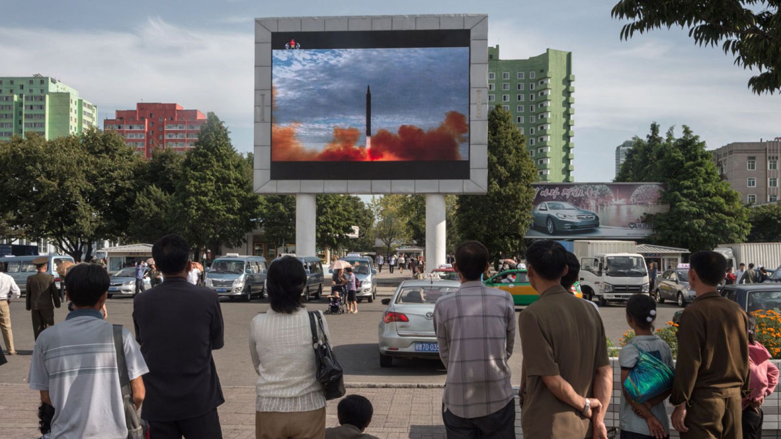 Ciudadanos norcoreanos observan el misil lanzado por Pyongyang en la televisión