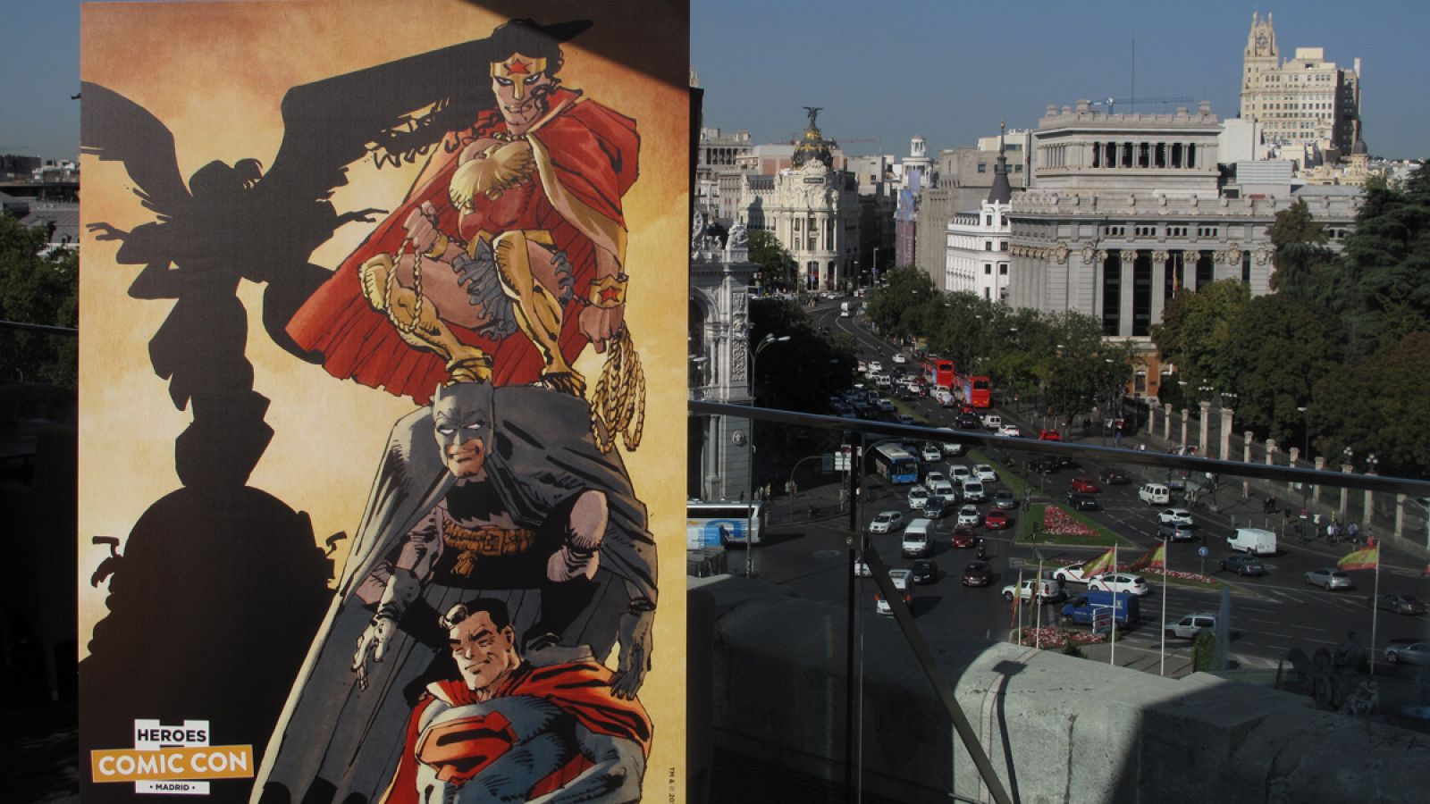 El cartel de Heroes Comic Con Madrid con el edificio Metrópolis de fondo