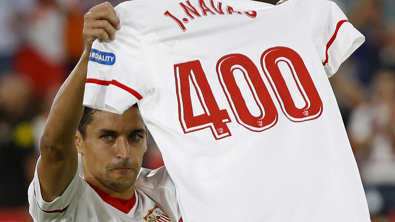 El centrocampista del Sevilla, Jesús Navas, muestra una camiseta celebrando su partido 400 con el equipo.