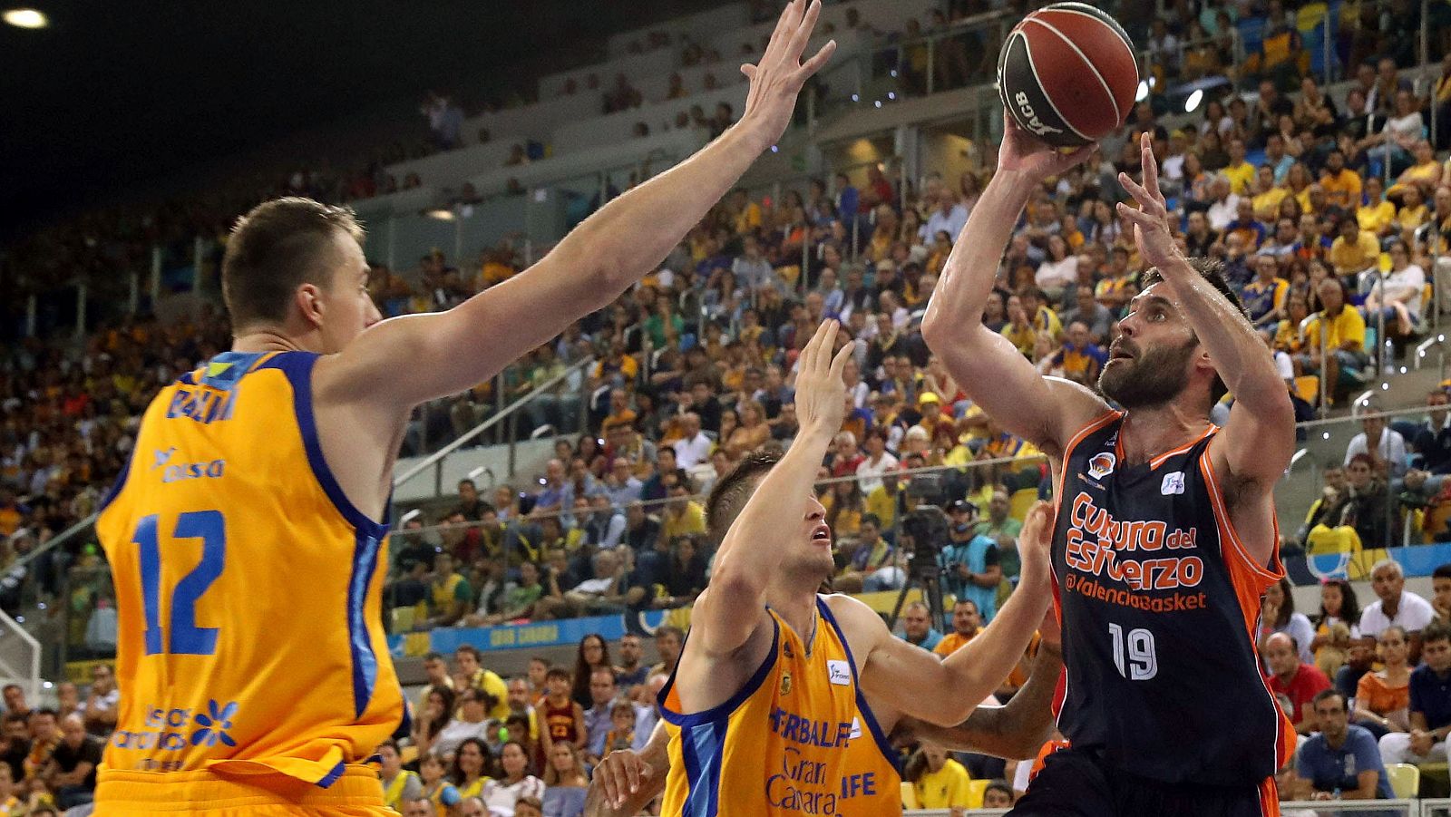 Los jugadores del Herbalife Gran Canaria Anzejs Pasecniks y Xavi Rabaseda, y el jugador del Valencia Basket Fernando San Emeterio.