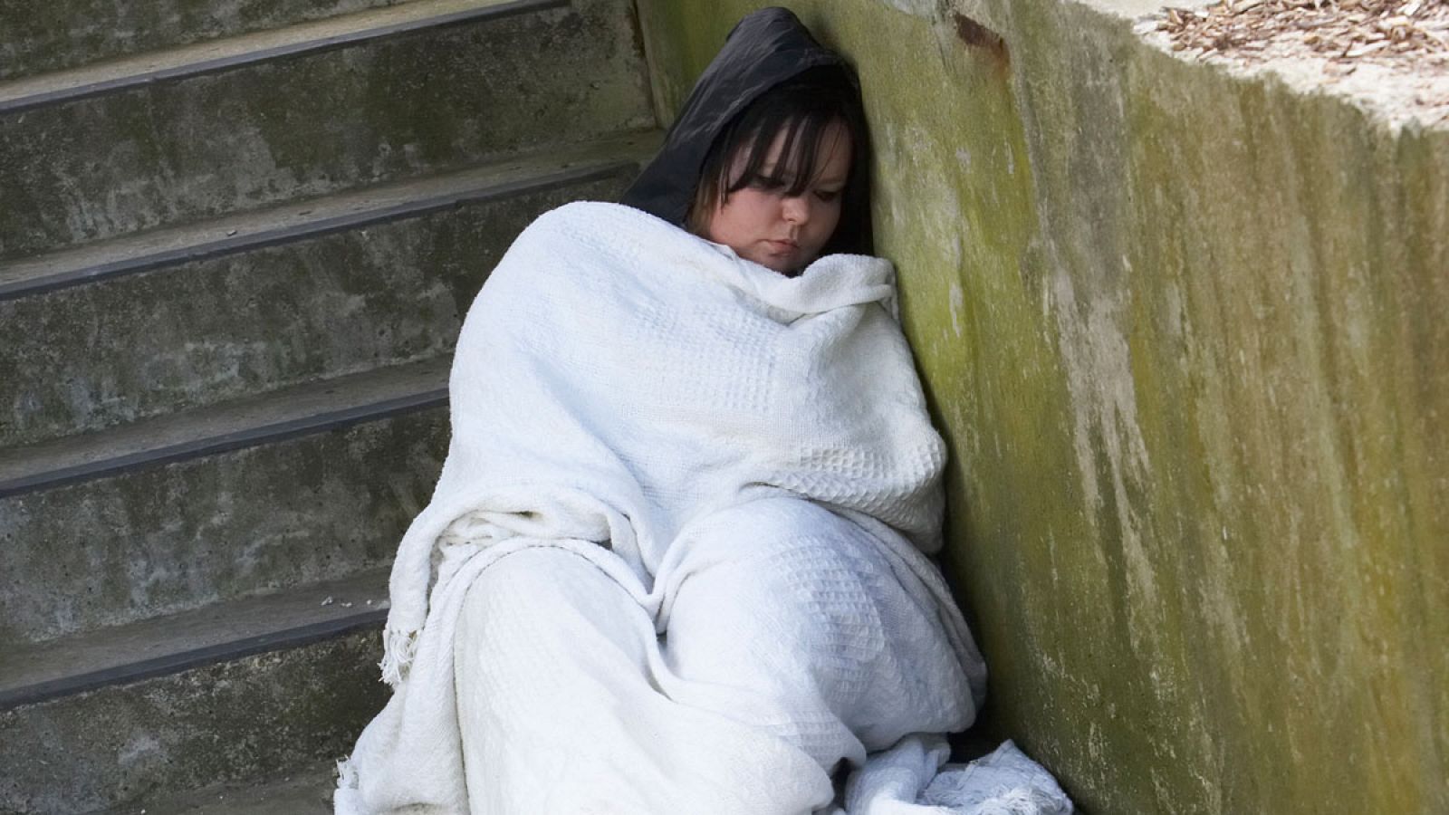 Una joven sin hogar durmiendo en la calle