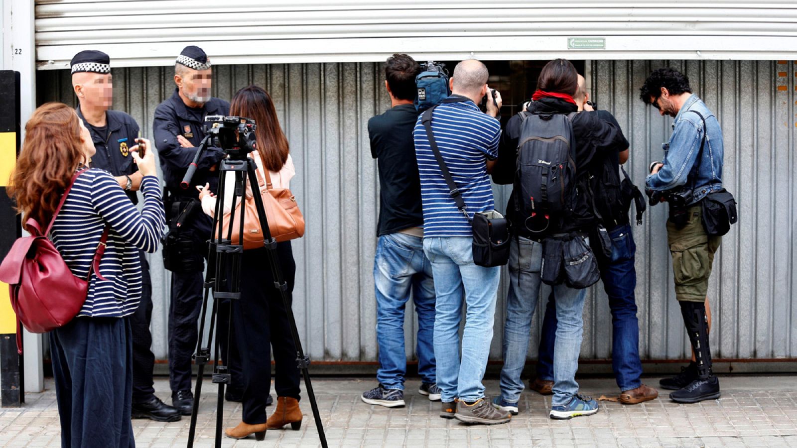 Fotógrafos y cámaras fotografían y graban el interior del almacén municipal en Barcelona donde se guardan las urnas del Estado para procesos electorales.