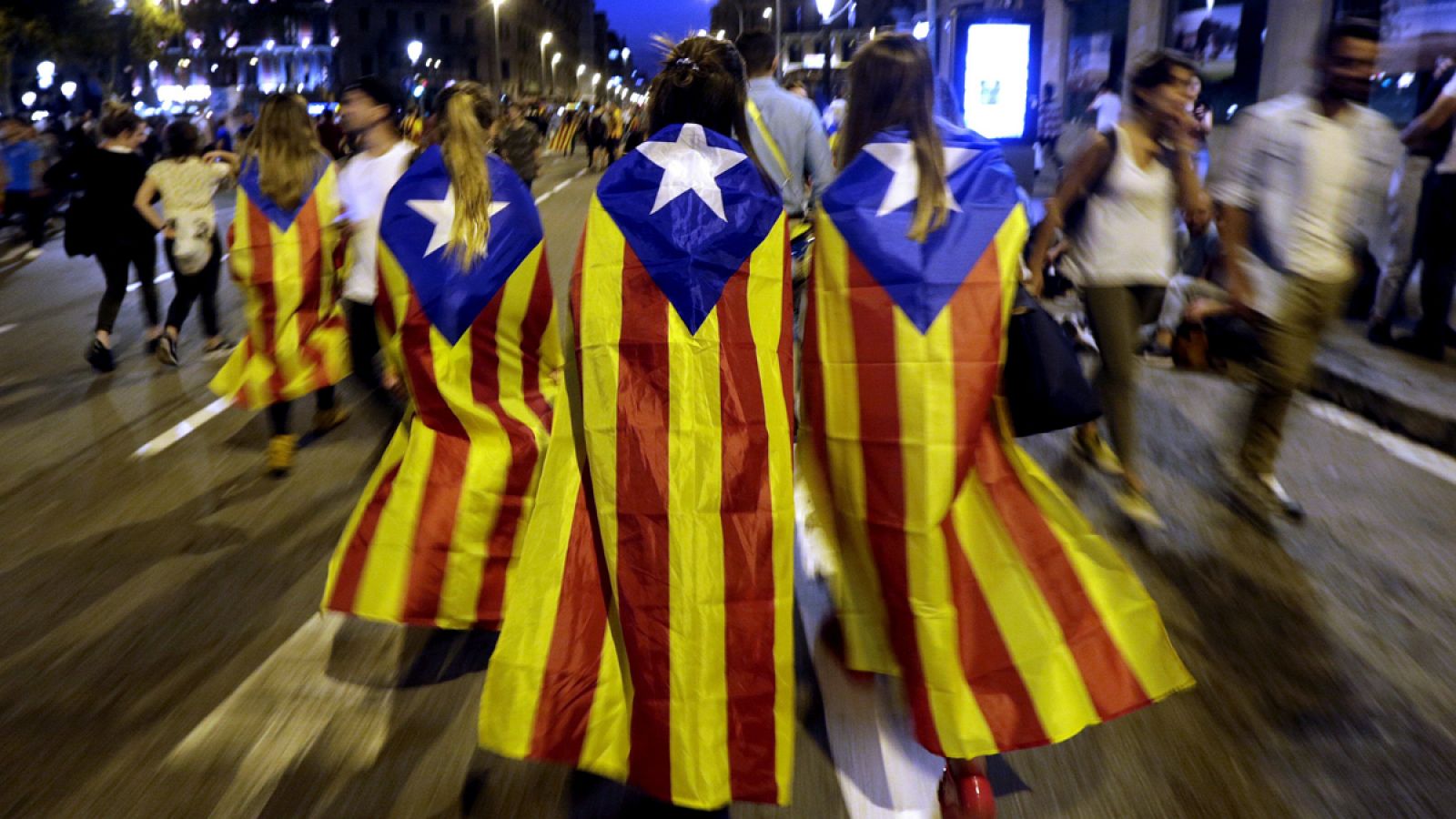 Varias jóvenes con banderas esteladas caminan por plaza de Catalunya