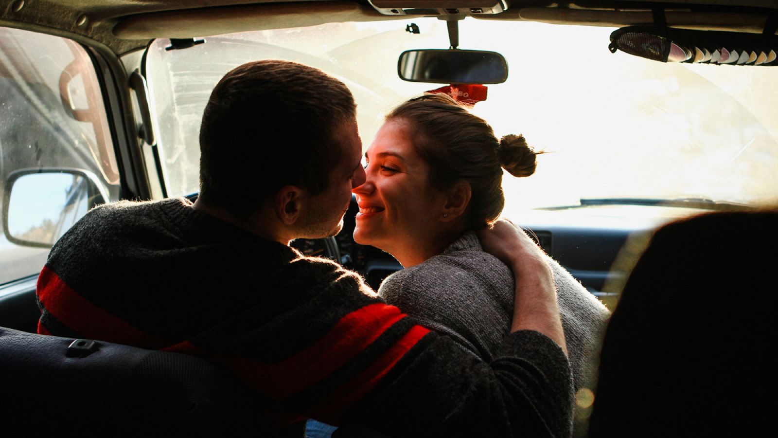 Una imagen de una pareja besándose en el interior de un coche