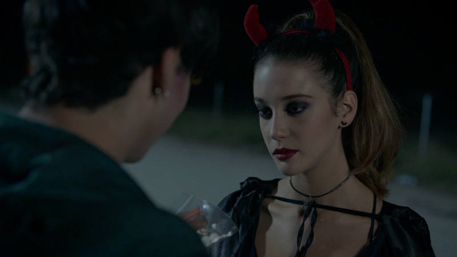 Rafa (Óscar Casas) le ofrece a Alba (María Pedraza) unas pastillas antes de entrar en la fiesta de Halloween