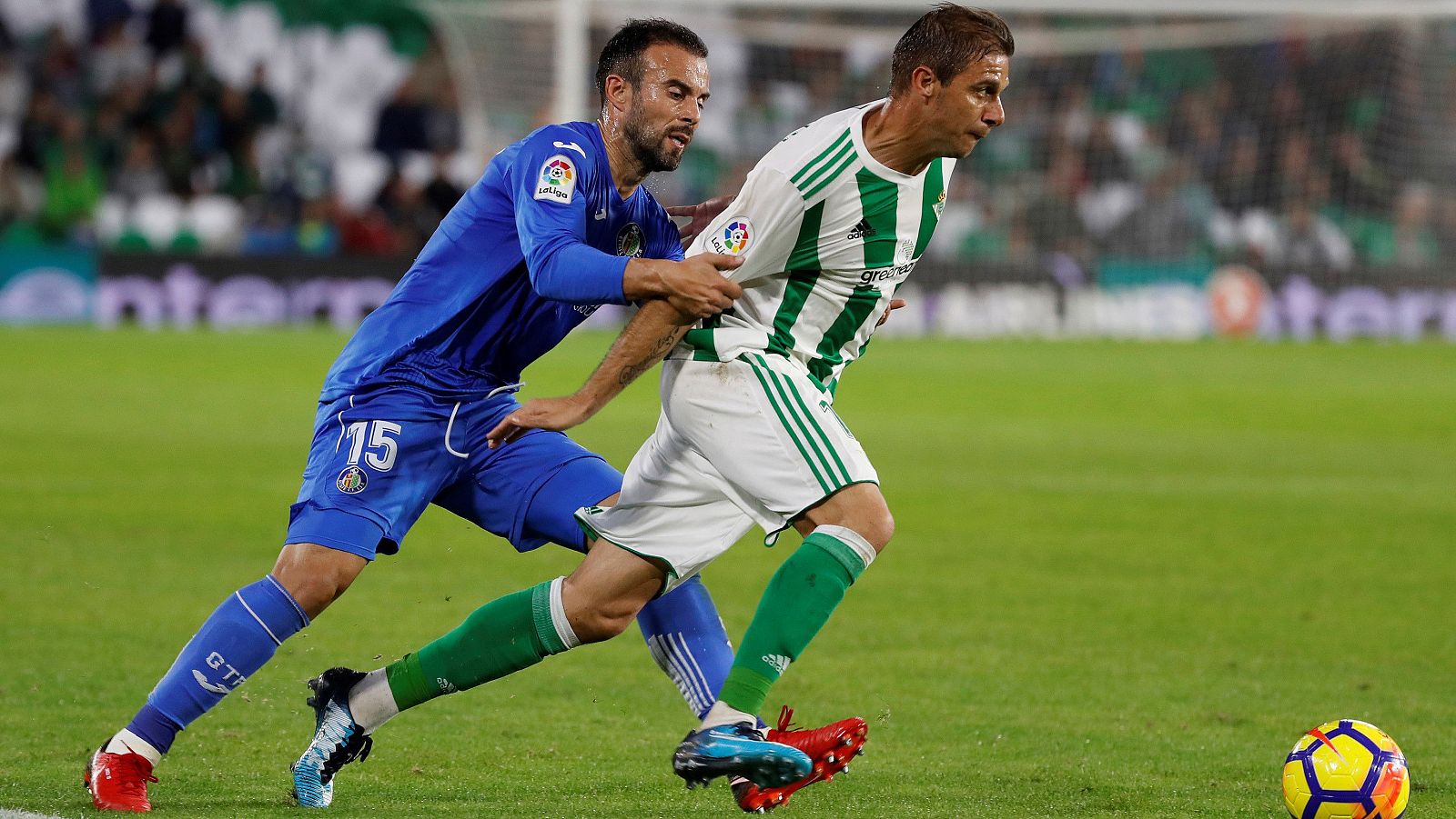 Joaquín trata de zafarse de Molinero en el Betis-Getafe.