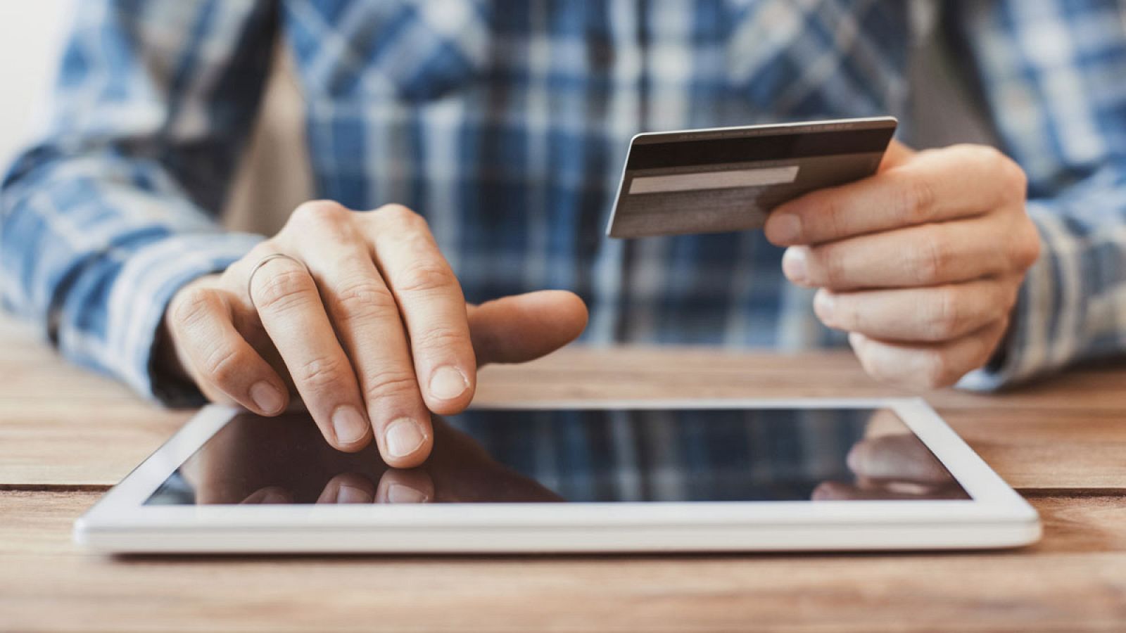 Un hombre realiza una compra por internet y paga con tarjeta bancaria
