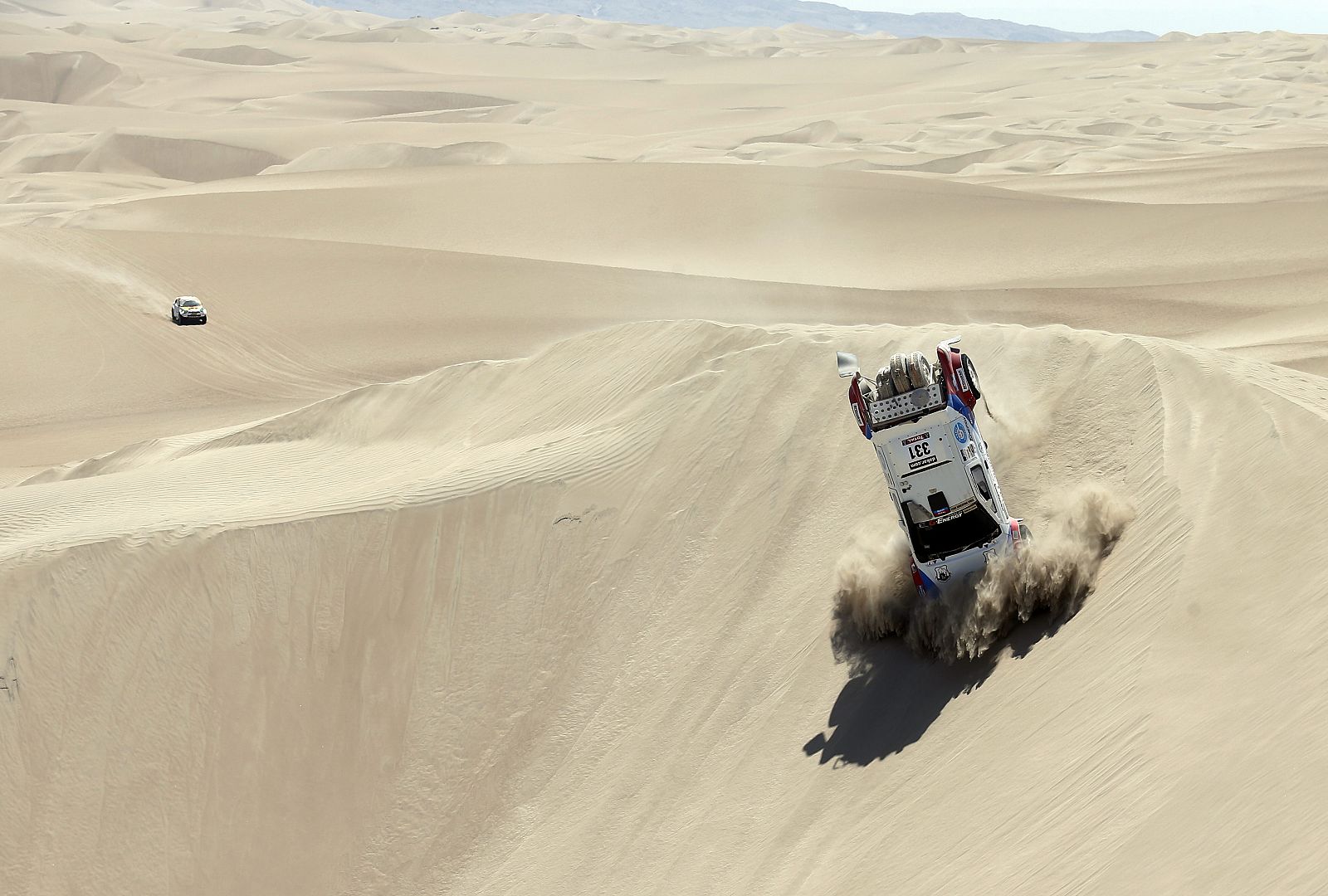 Un coche vuelca en una duna del Dakar 2013, en el desierto de Nasca (Perú).
