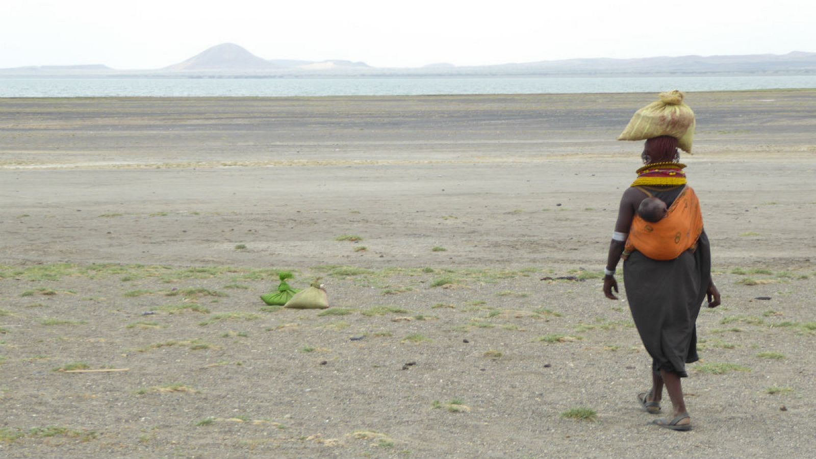 Una mujer camina hacia su poblado a orillas del lago Turkana