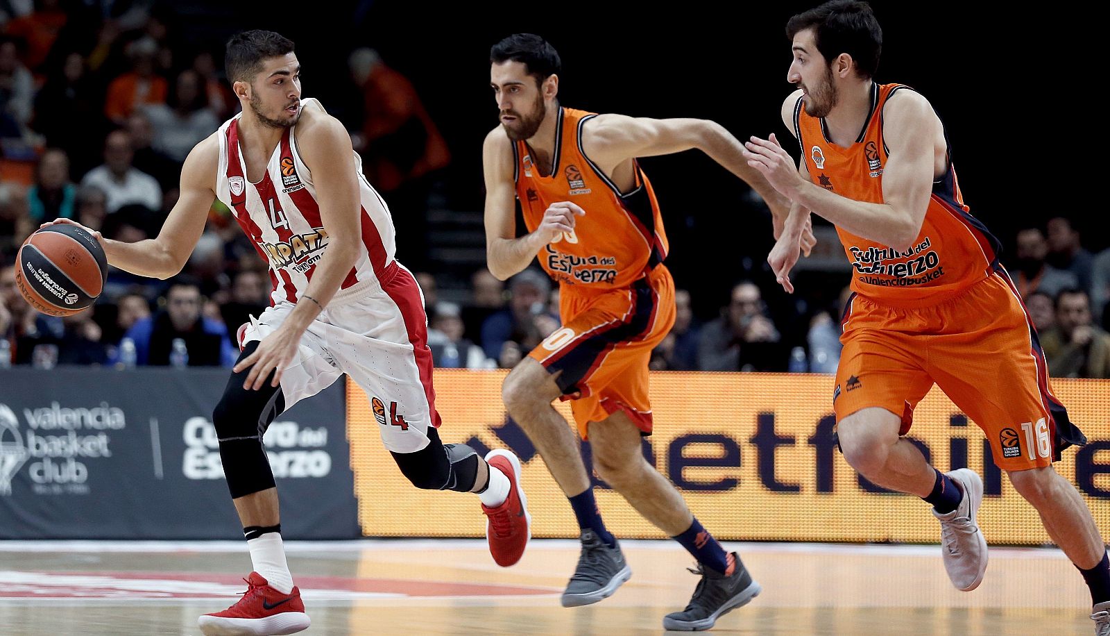 El escolta de Olympiacos Vassilis Toliopoulos (i) se escapa de Joan Sastre (c) y Guillem Vives, del Valencia Basket.