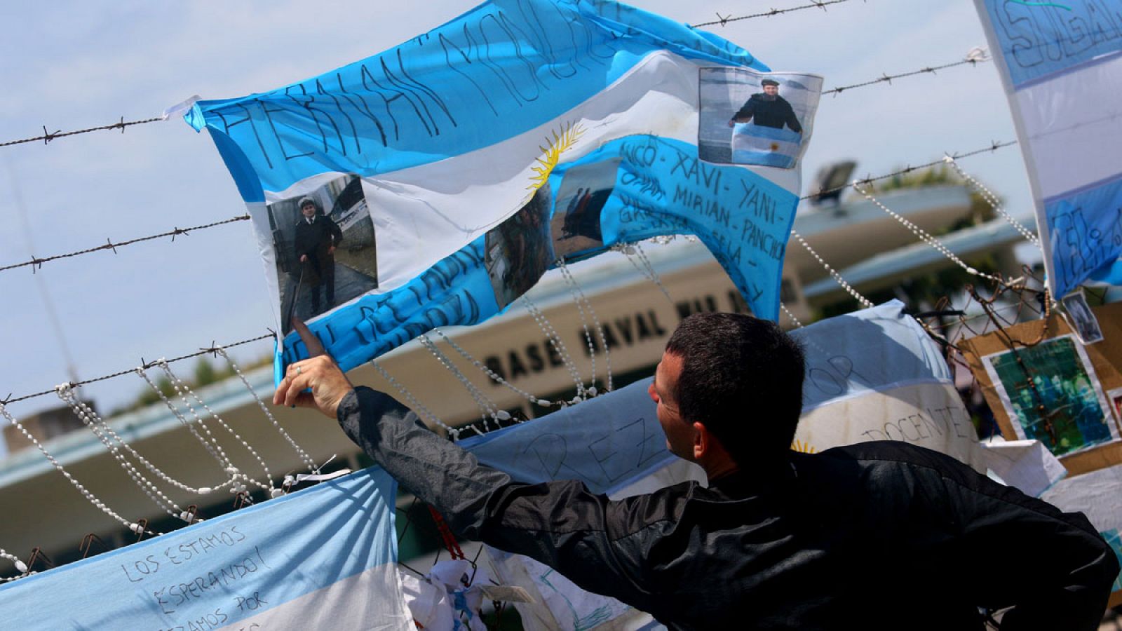 Un hombre cuelga una bandera para brindar su apoyo a los familiares de los submarinistas en el exterior de la Base Naval Mar del Plata (Argentina).