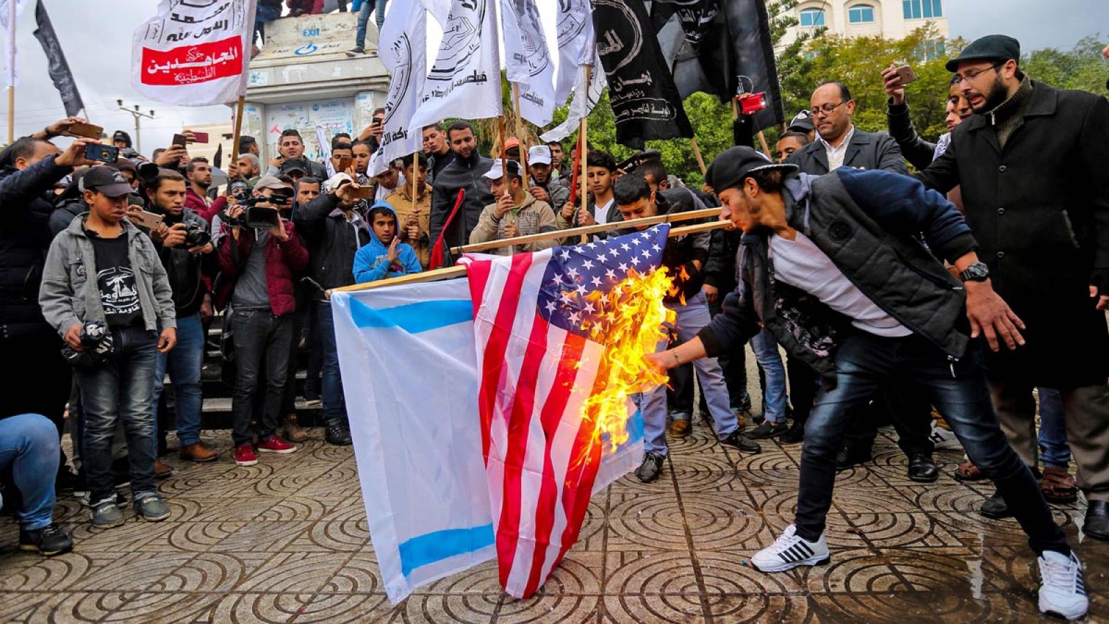 Manifestantes palestinos queman una bandera de Estados Unidos y otra de Israel en Gaza.
