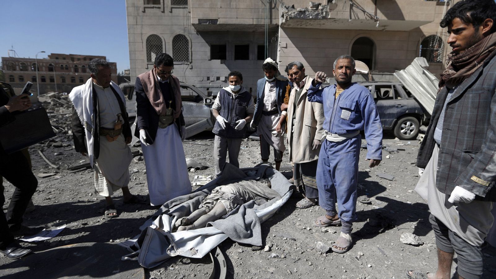 Hutíes yemeníes contemplan el cadáver de un fallecido tras el bombardeo a la prisión en Saná