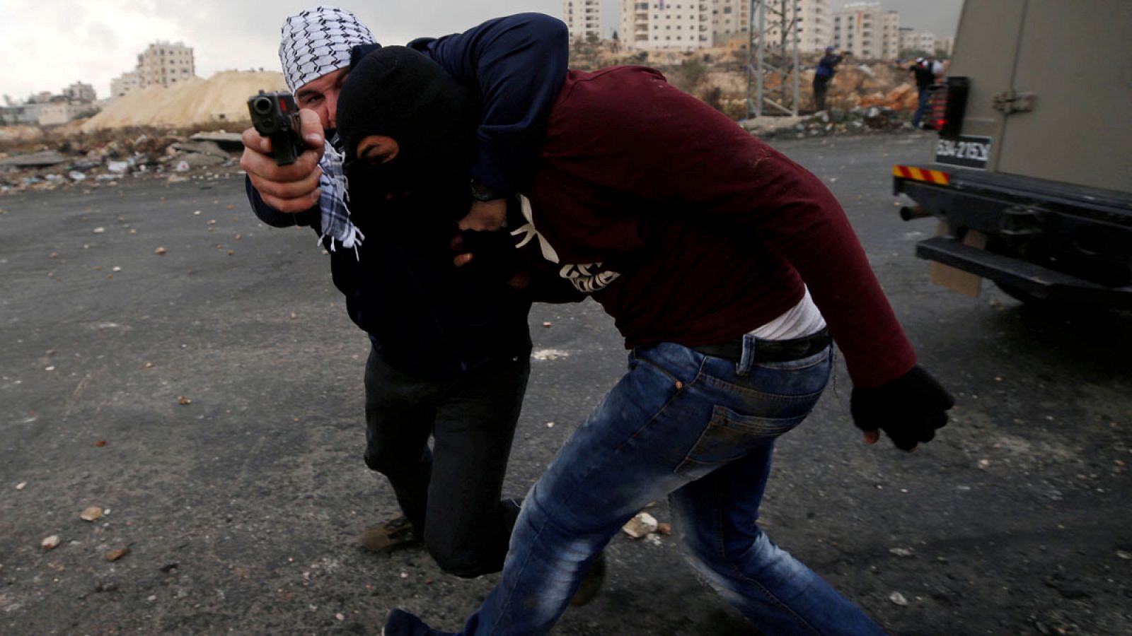 Un agente israelí de incógnito apunta con un arma a un fotógrafo de Reuters