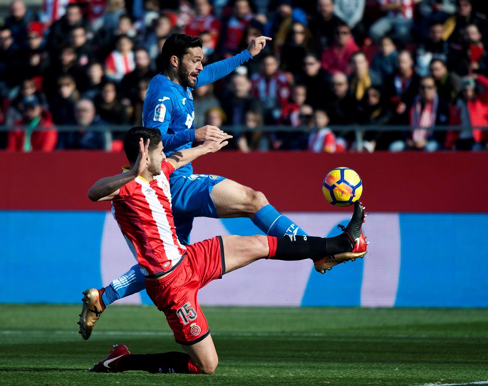 El delantero del Getafe Jorge Molina (d) disputa un balón con el defensa del Girona Juan Pedro Ramírez 'Juanpe' (i) durante el partido.