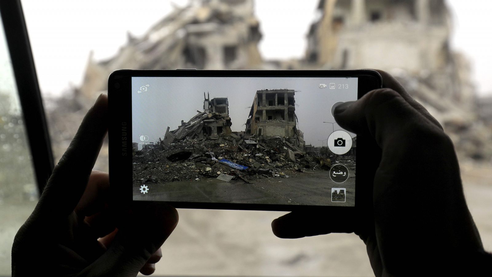 Un miliciano del Ejército de Siria Democrática toma una foto con su teléfono en la ciudad siria de Raqa