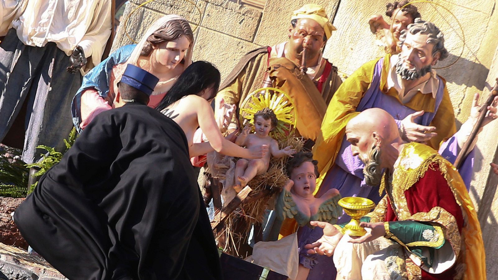 Una activista de Femen intenta llevarse la figura del niño Jesus del belén del Vaticano el diá de Navidad