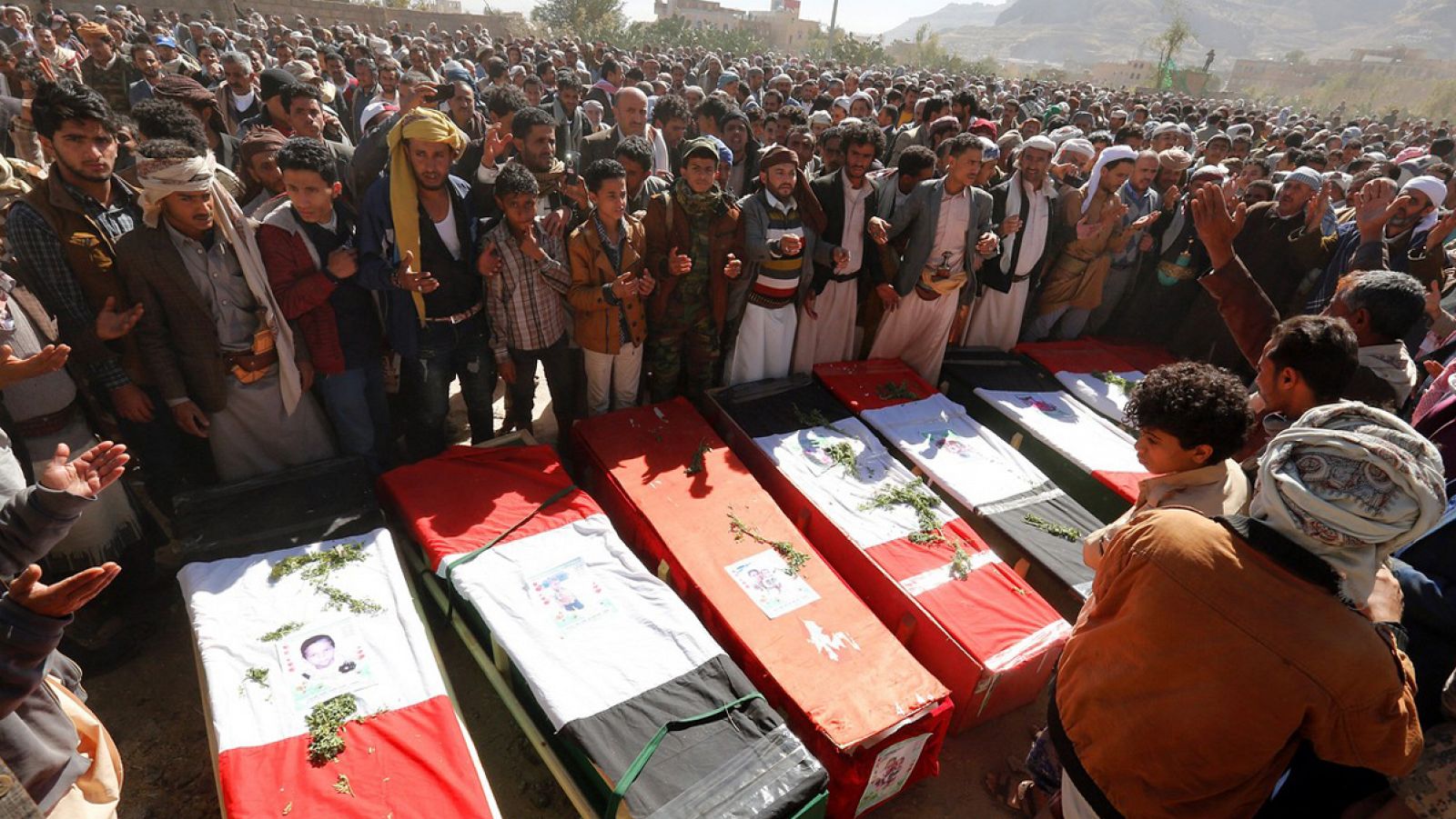 Yemeníes rezan frente a las lápidas de las víctimas de un bombardeo de la coalición árabe comandada por Arabia Saudí