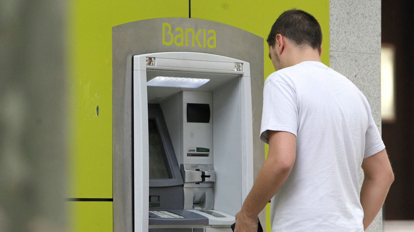 Un cliente saca dinero en una sucursal de Bankia
