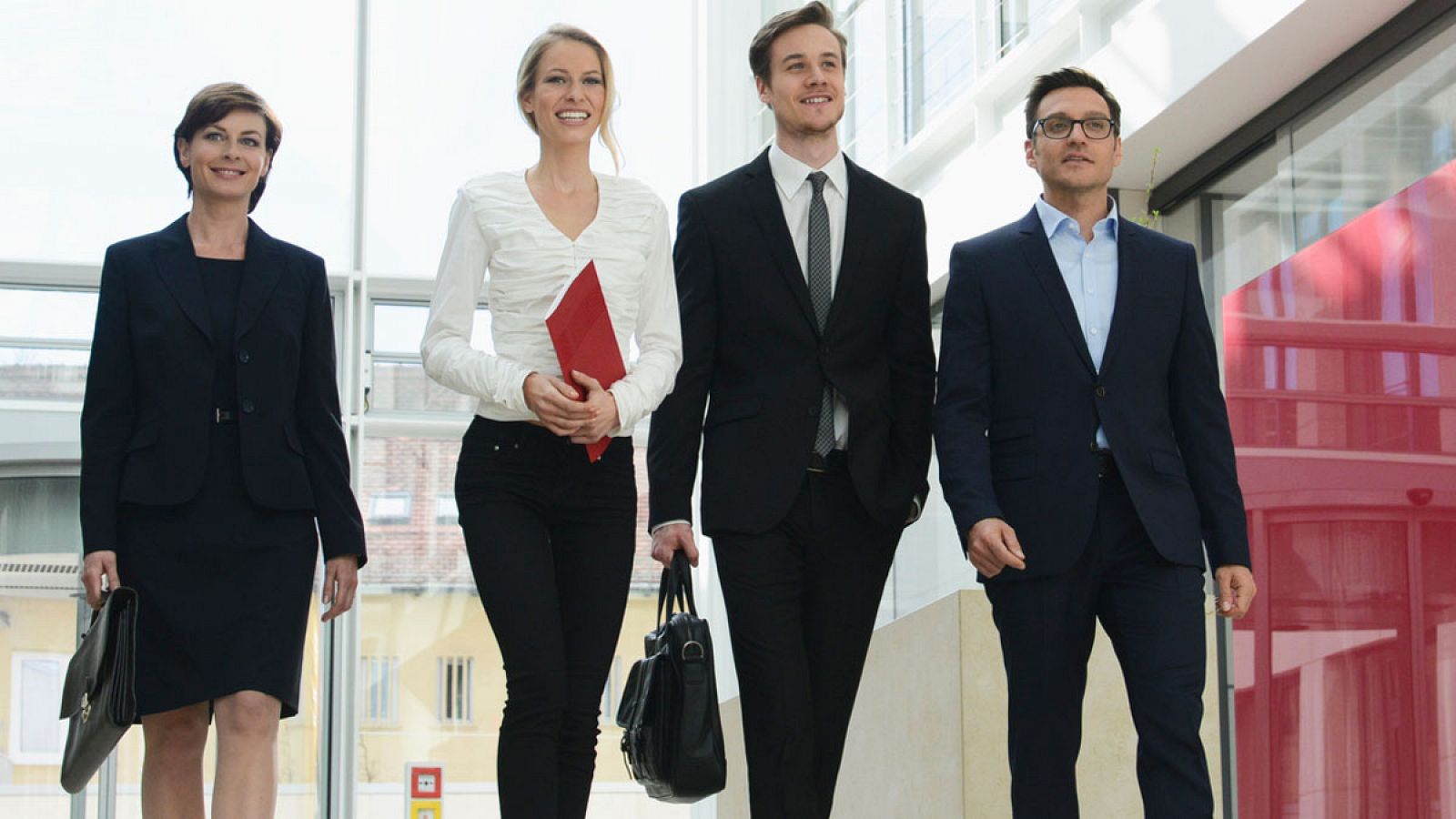 Dos mujeres y dos hombres se dirigen a una reunión de trabajo