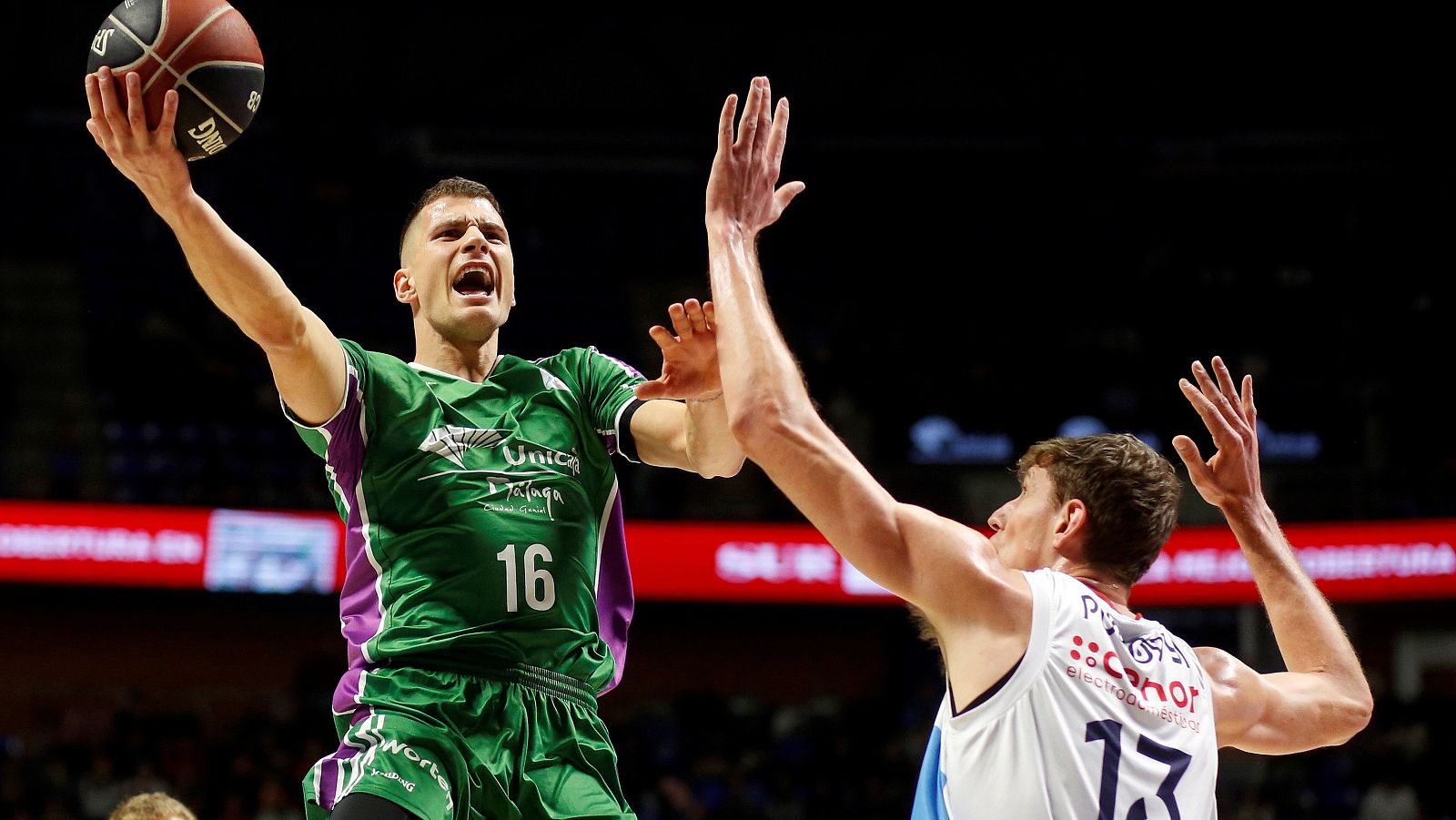 El serbio del Unicaja, Nemanja Nedovic (i), lanza a canasta ante lel ucraniano del Monbus Obradoiro, Artem Pustovyi (d).