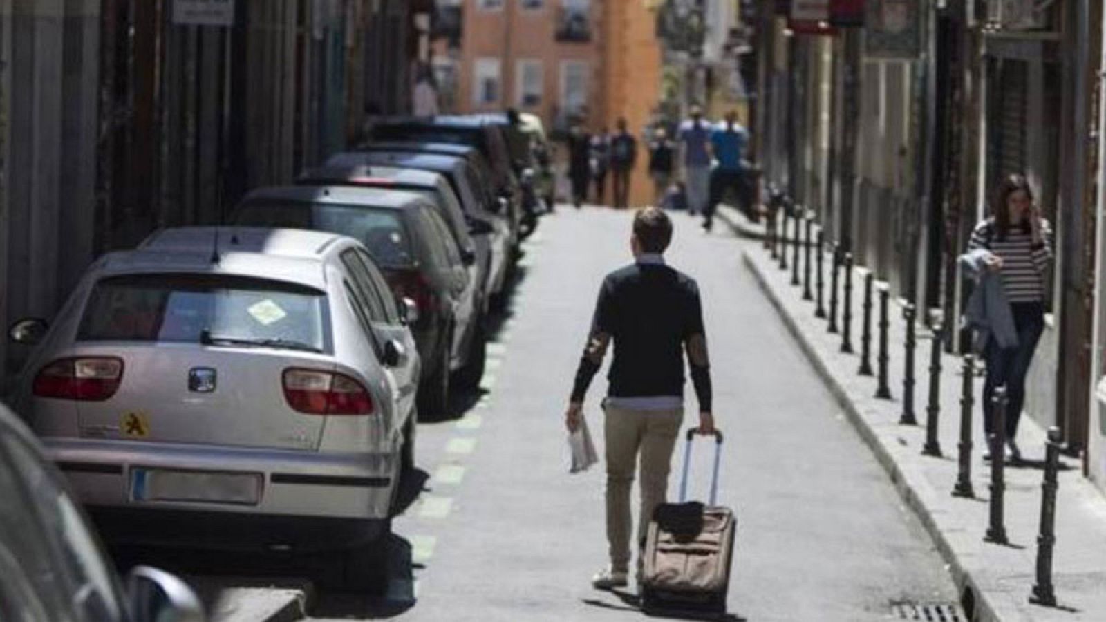 Un turista sube con su equipaje por una calle del centro de Madrid