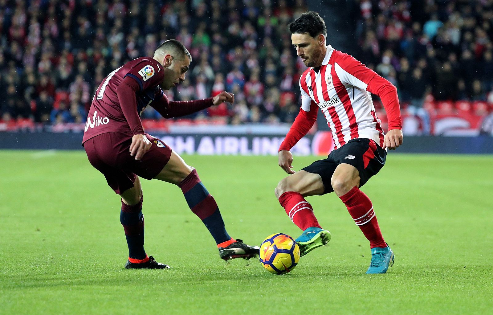El delantero del Athletic de Bilbao Aritz Aduriz (d) disputa un balón con Rubén Peña, defensa de la SD Eibar.