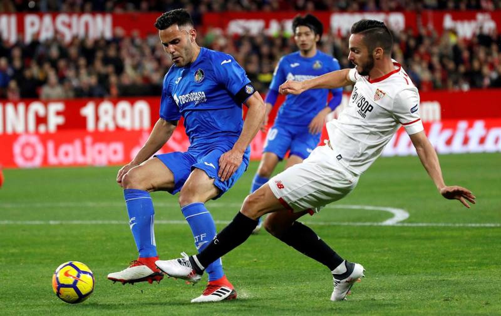 El delantero del Sevilla Pablo Sarabia (d), pelea un balón con el defensa del Getafe Bruno González.