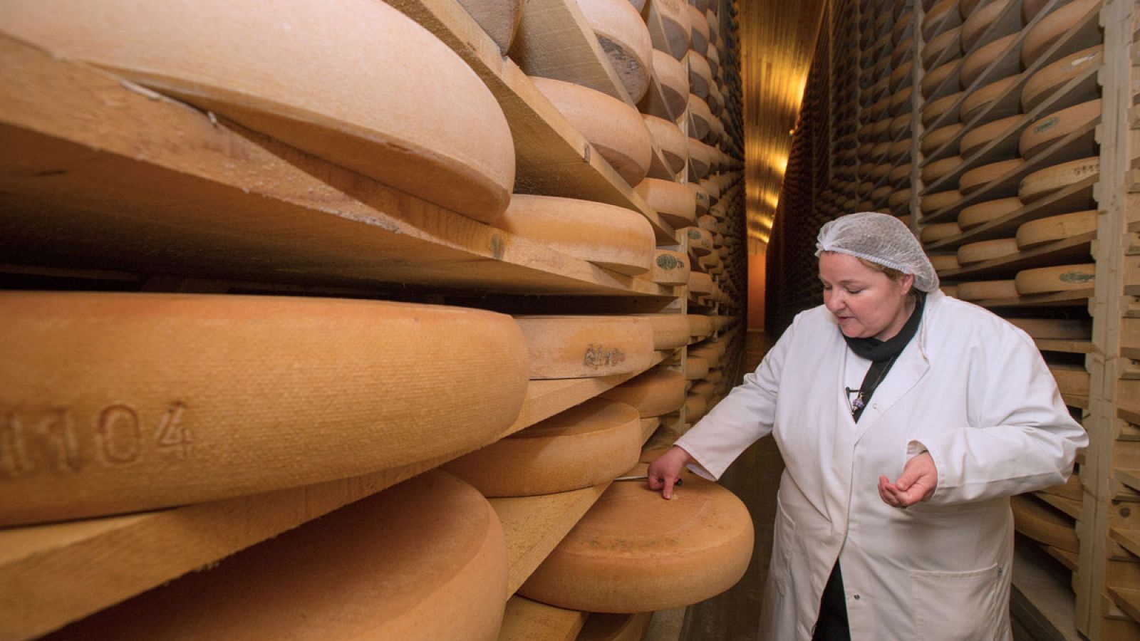 Una empleada de una productora de queso Comté en un almacén en la localidad francesa de Montmorot