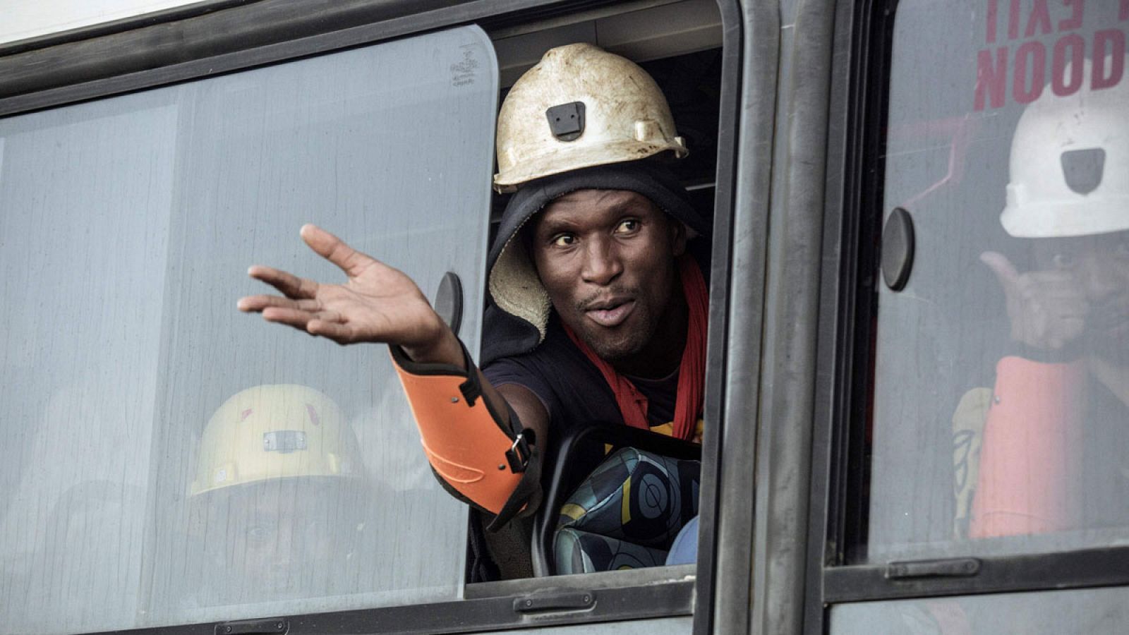 Uno de los mineros rescatados saludando a través de la ventana de un autobús.