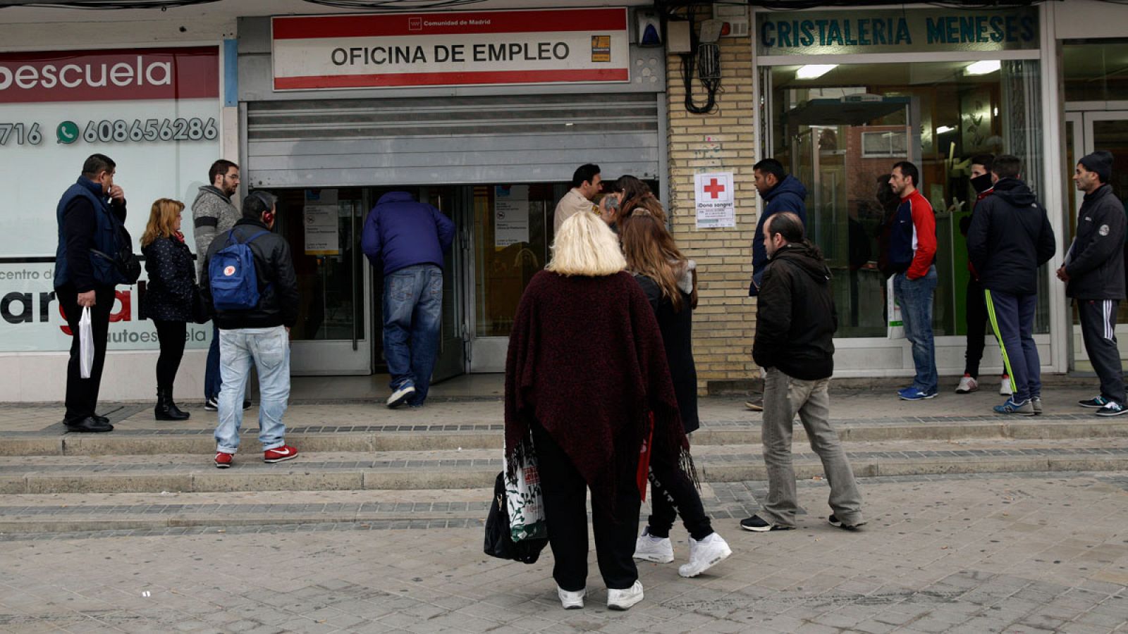 Varias personas esperan a que abra una oficina de empleo del centro de Madrid