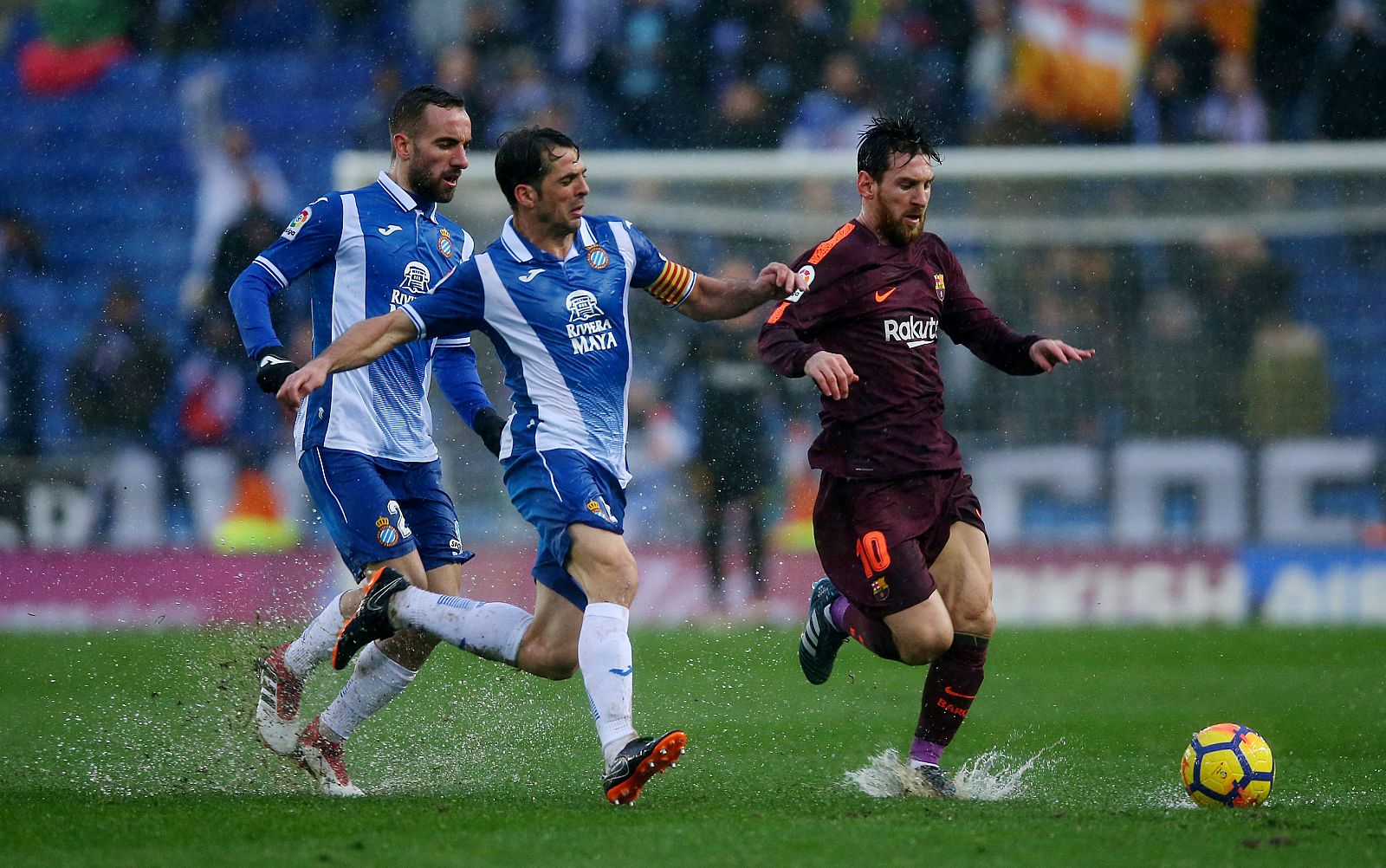 Leo Messi trata de superar a sus rivales durante el derbi liguero.